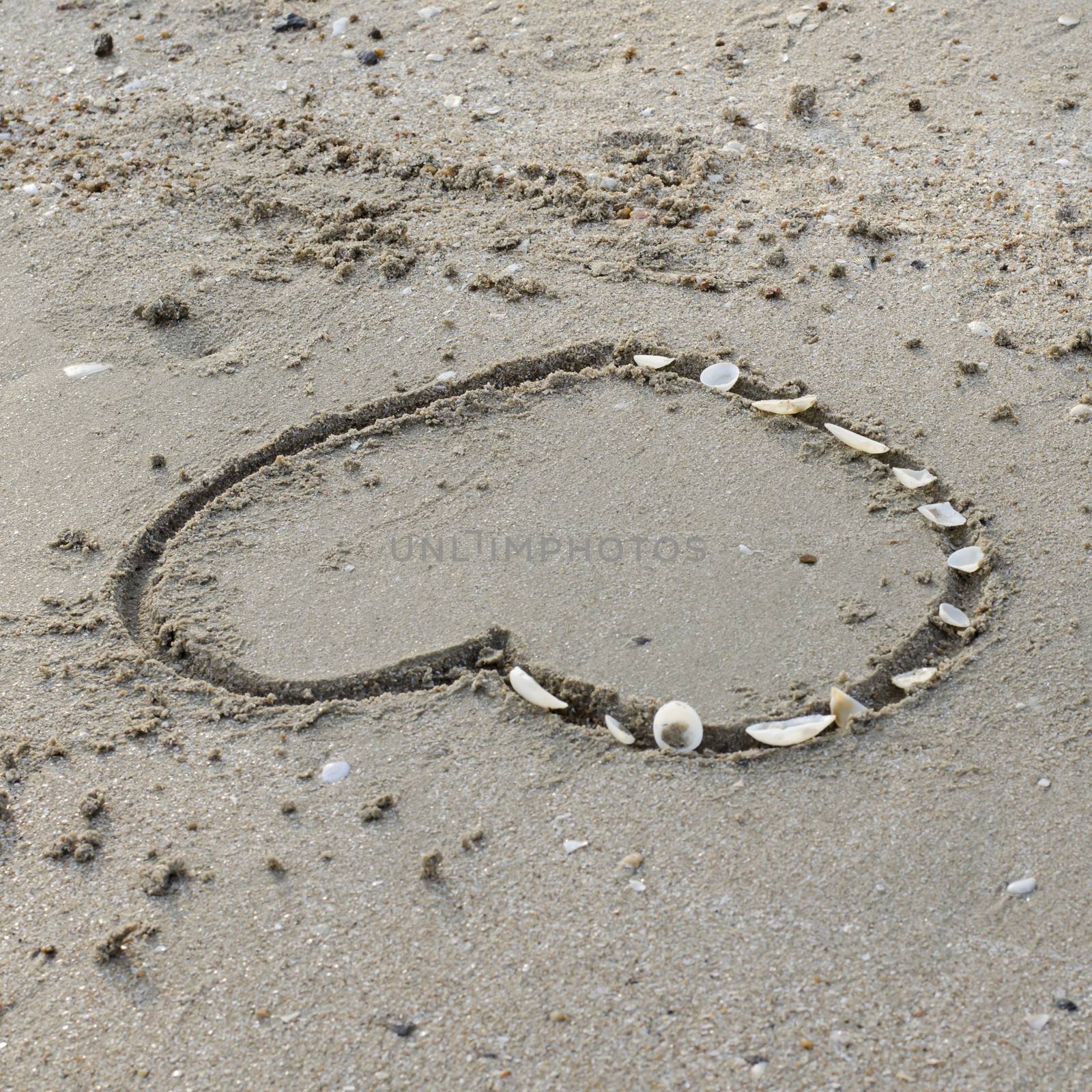 drawing heart on the sand in the beach