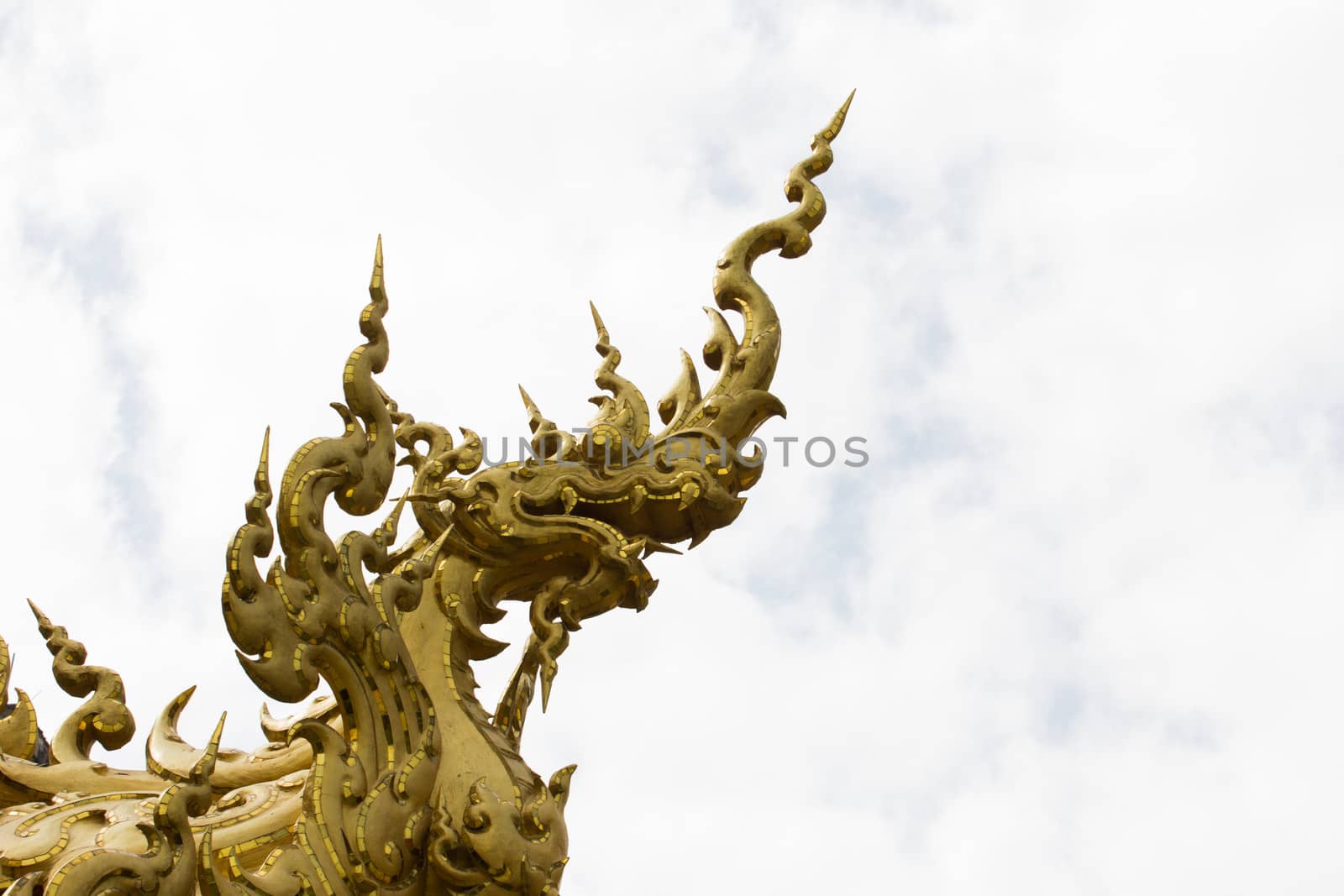 sculpture of golden snake in a white temple of Chiang Rai, in Thailand