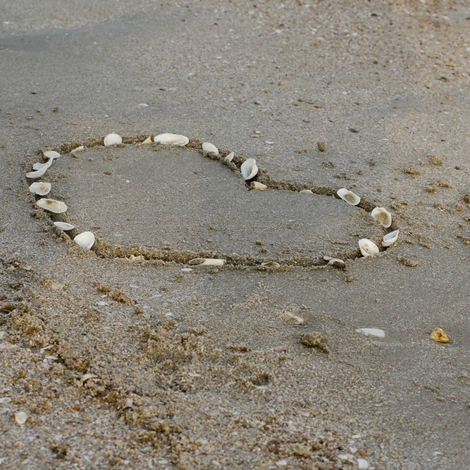 drawing heart on the sand in the beach