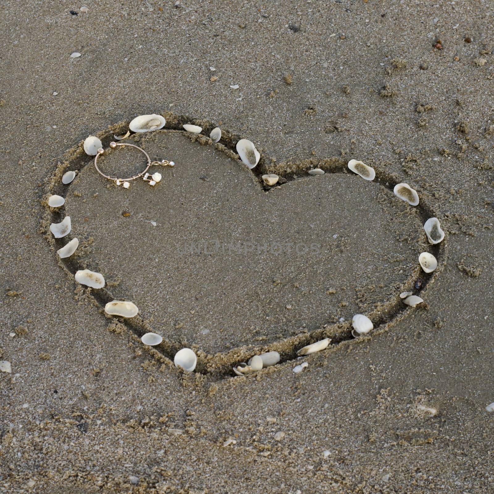 drawing heart on the sand in the beach