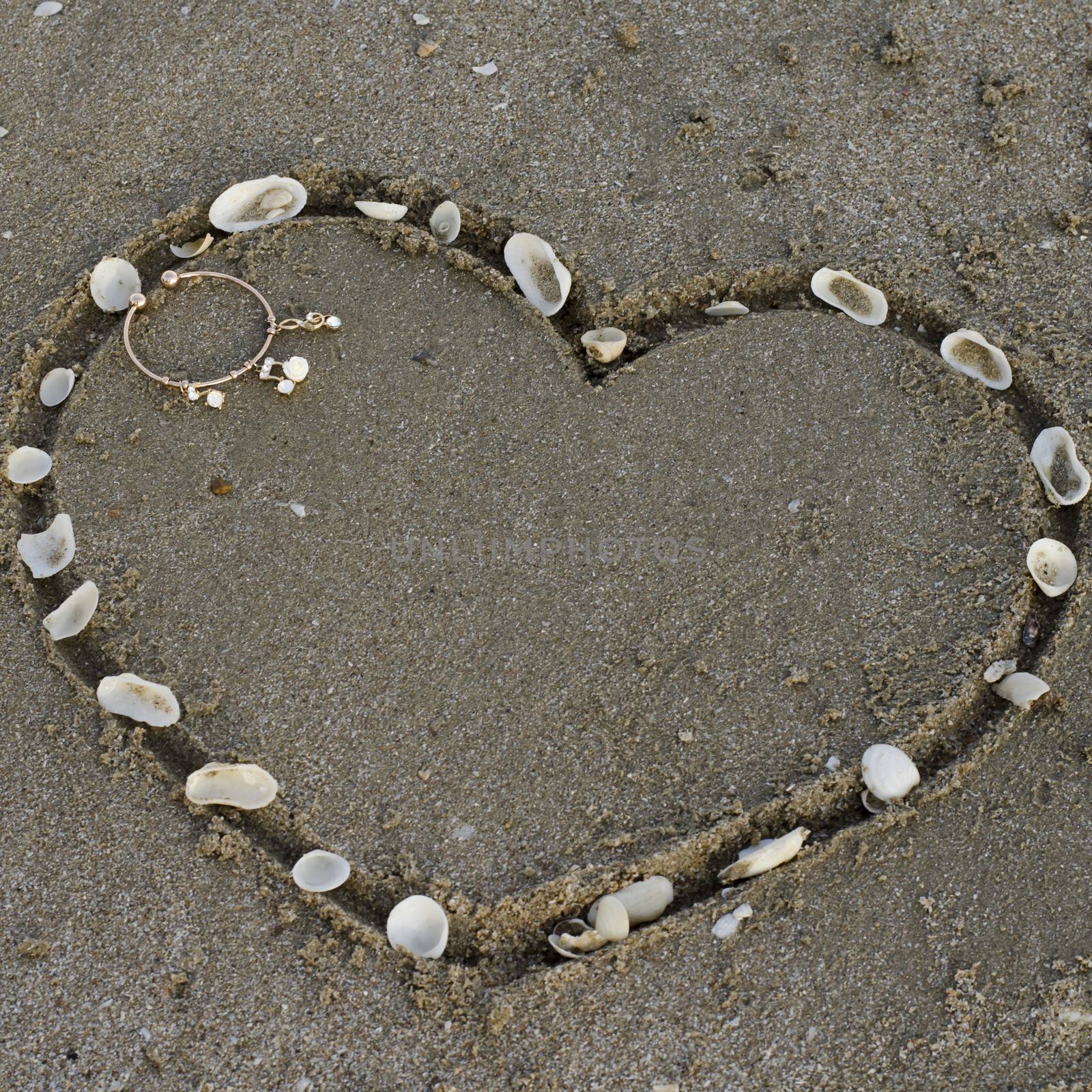 drawing heart on the sand in the beach