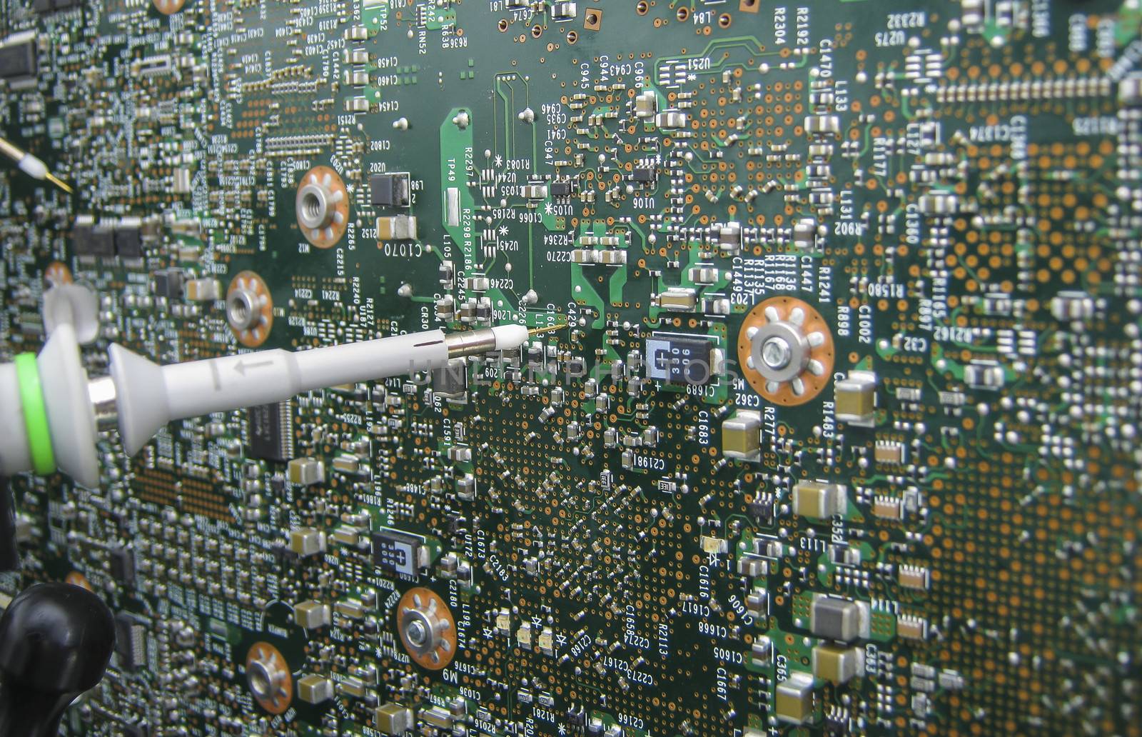Multimeter probes examining a circuit board  by Sorapop