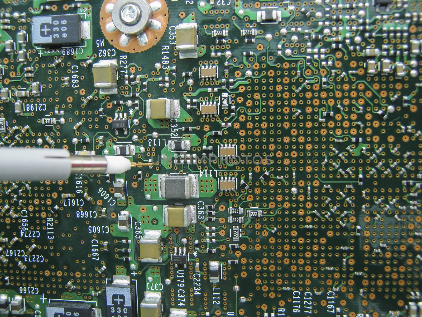 Multimeter probes examining a PCB circuit board