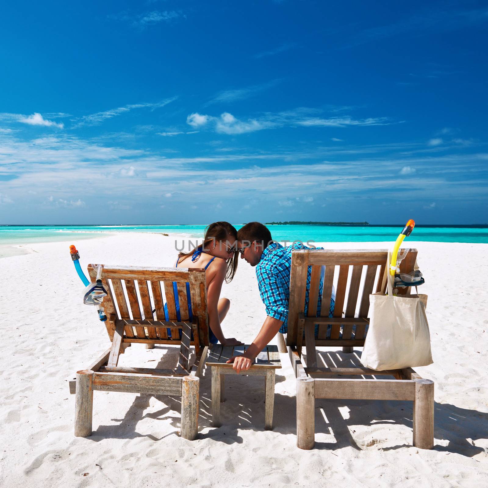 Couple relax on a tropical beach at Maldives