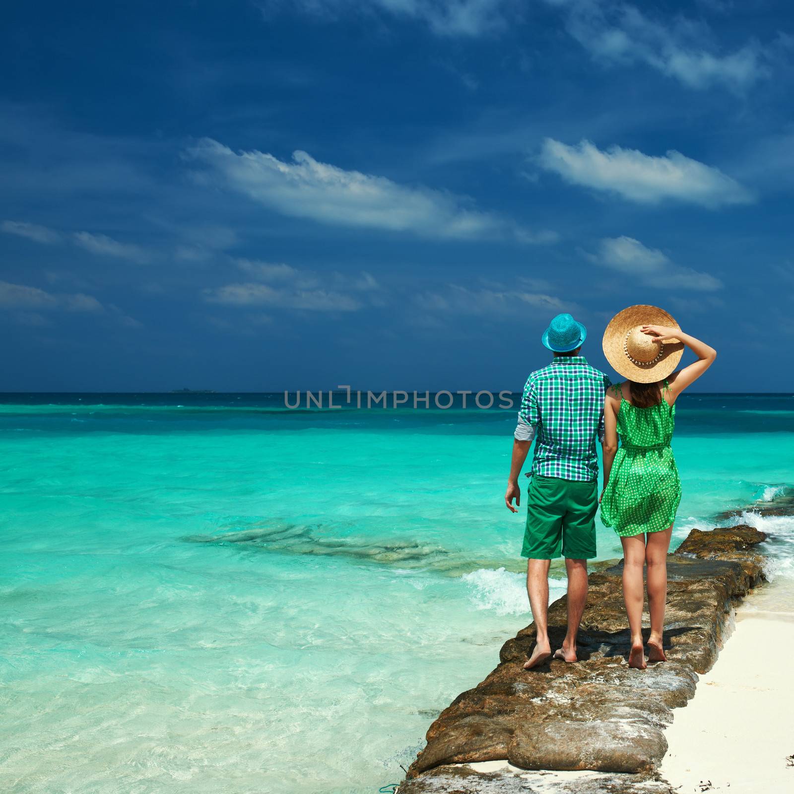 Couple in green on a tropical beach at Maldives