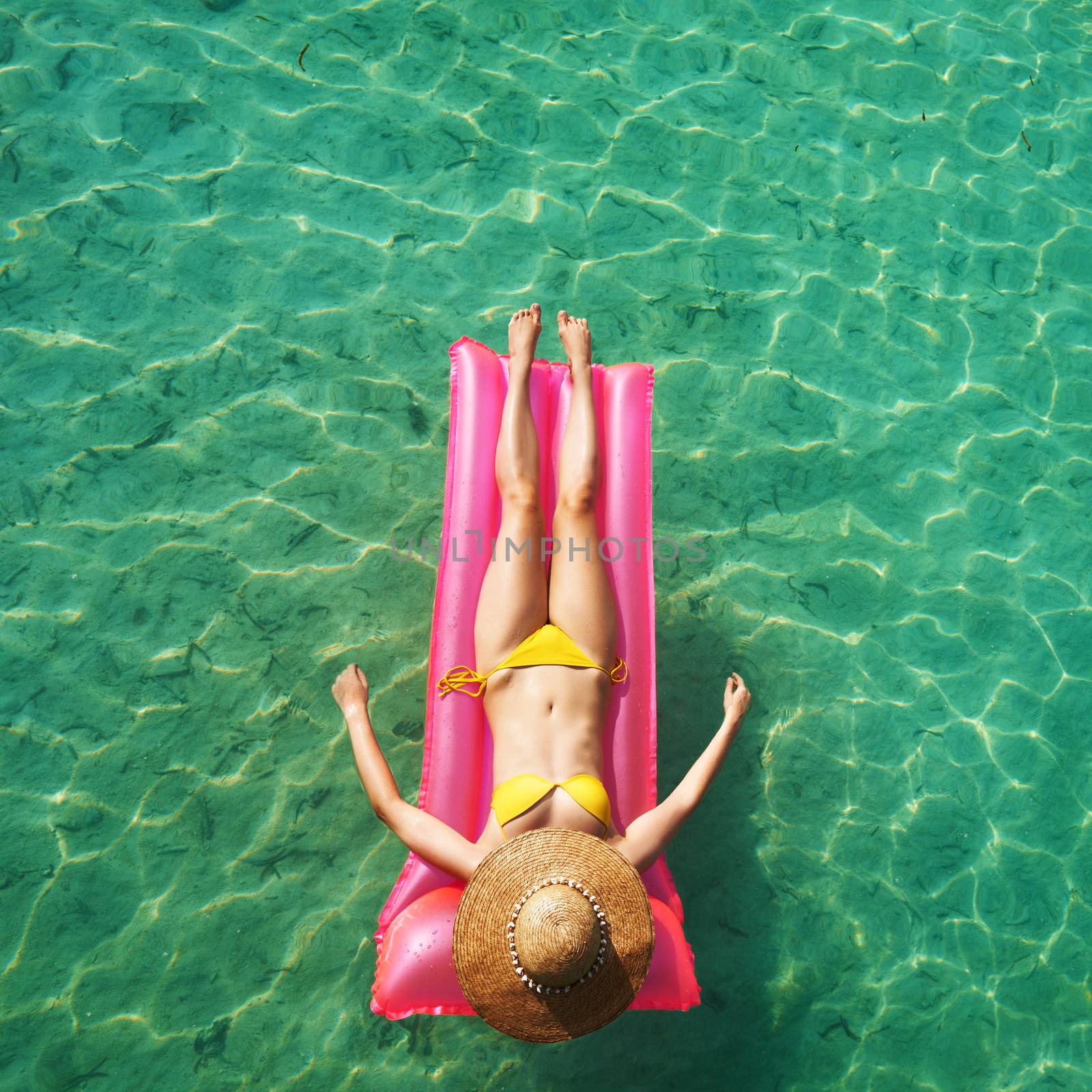 Woman relaxing on inflatable mattress at the beach