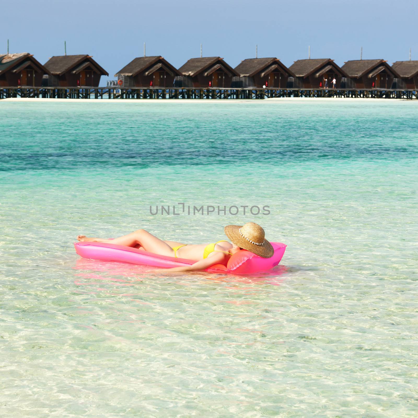 Woman relaxing on inflatable mattress at the beach