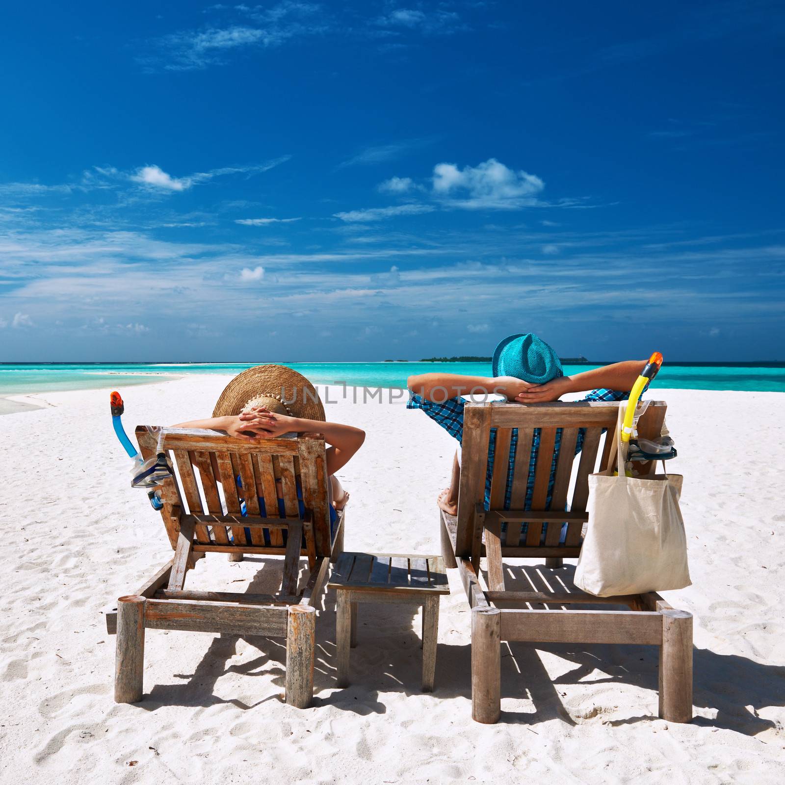 Couple relax on a tropical beach at Maldives