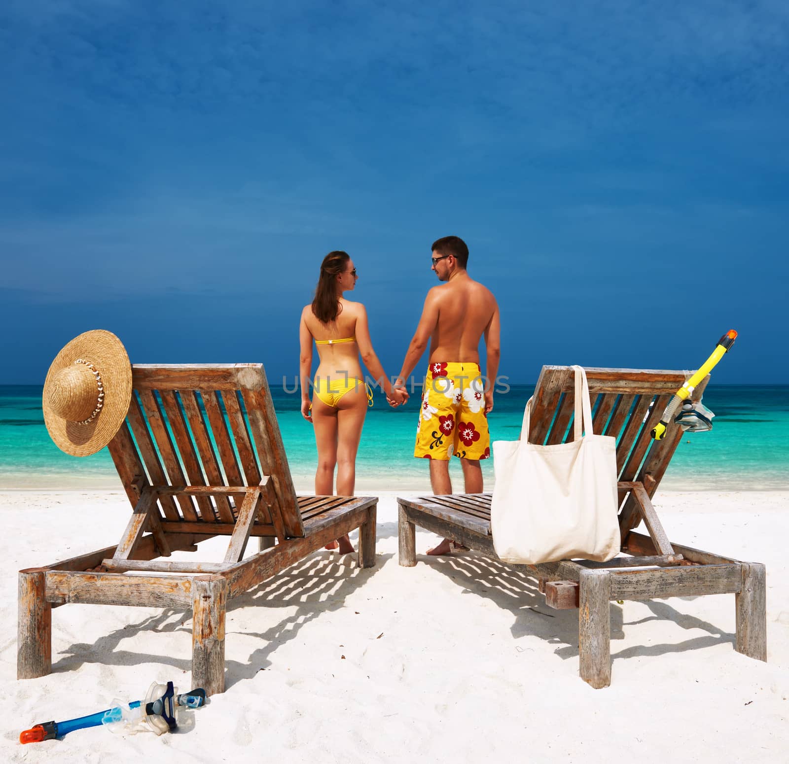 Couple in yellow on a tropical beach at Maldives