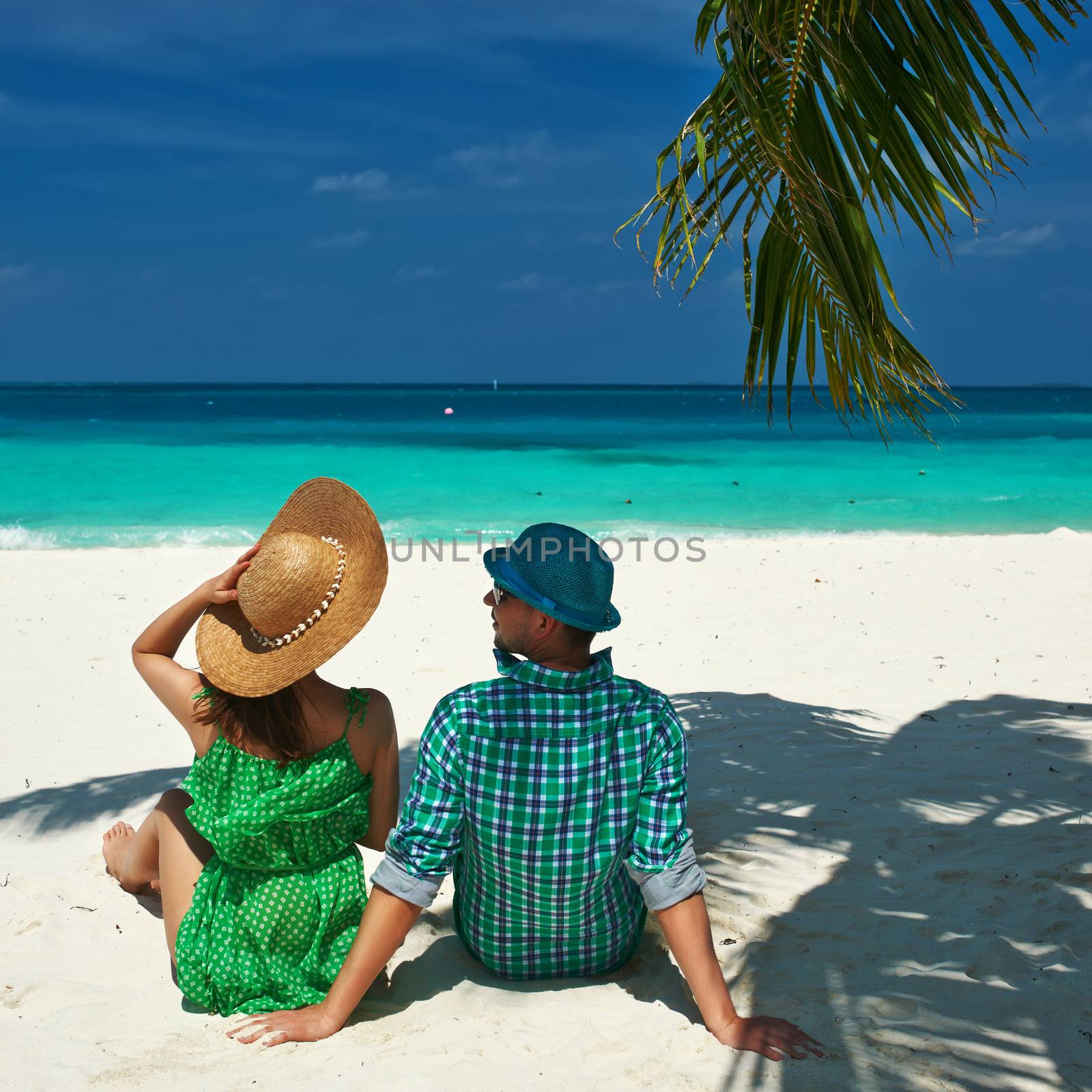 Couple in green on a tropical beach at Maldives