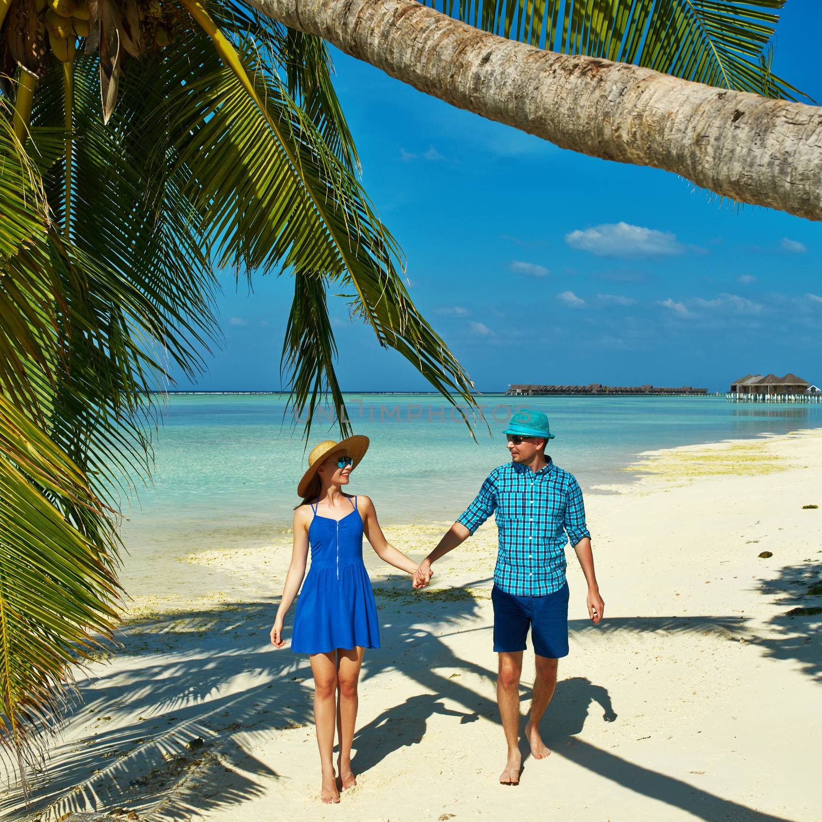 Couple in blue clothes on a tropical beach at Maldives