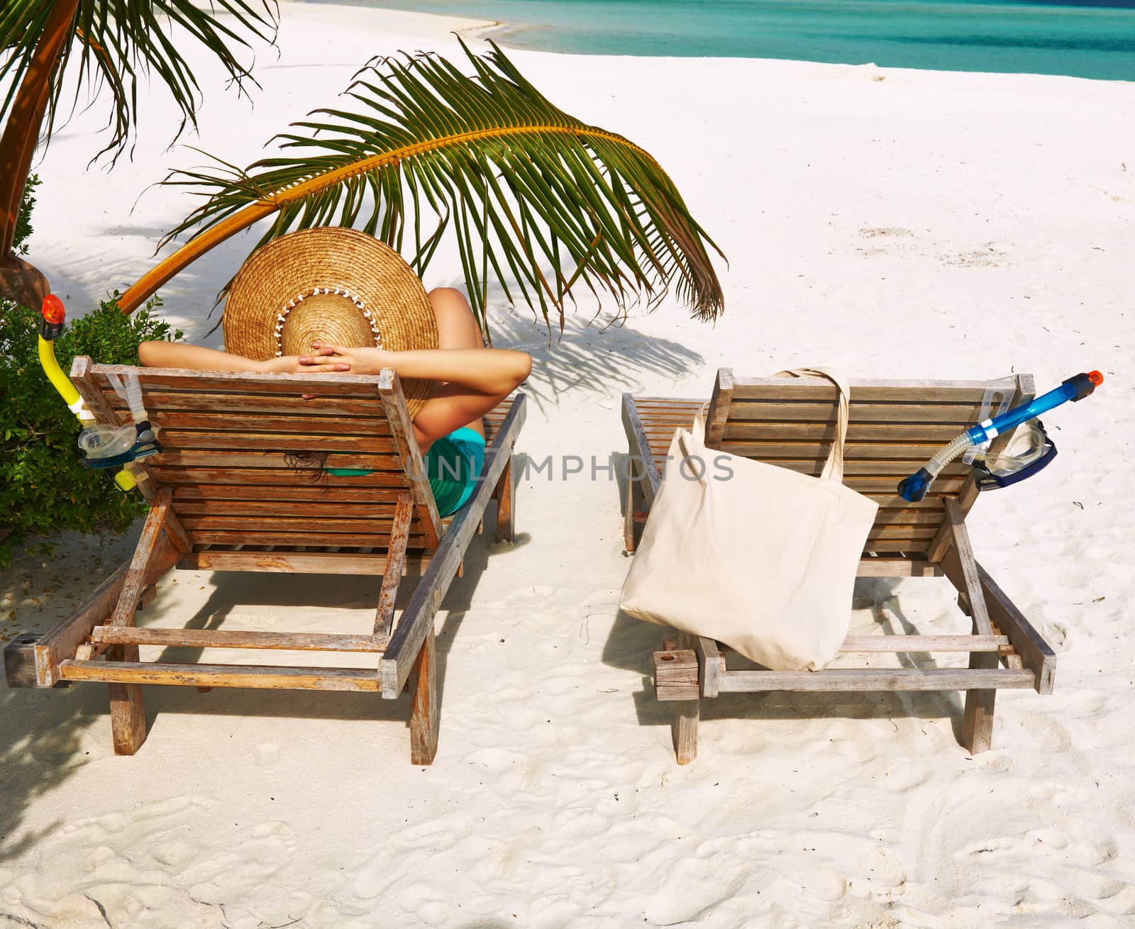 Woman at beach with chaise-lounges by haveseen