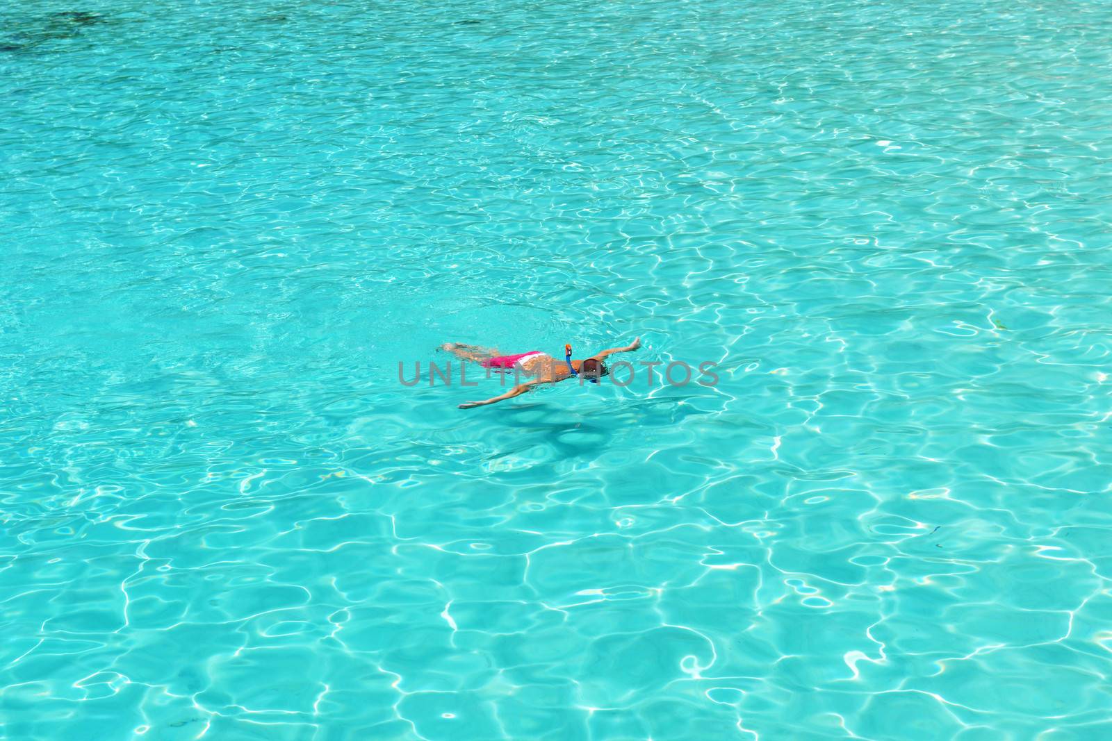 Man snorkeling in crystal clear turquoise water at tropical beach