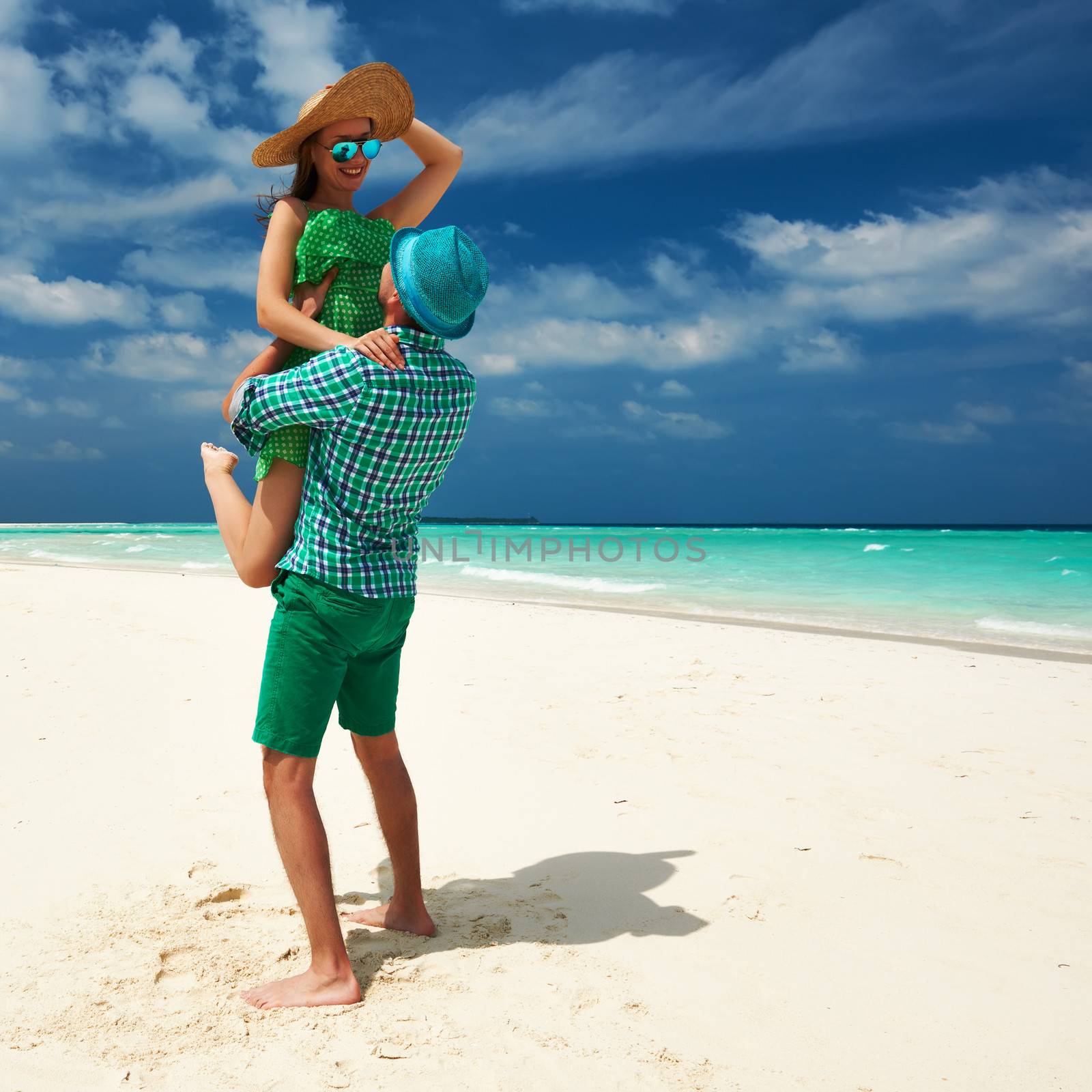 Couple in green on a tropical beach at Maldives