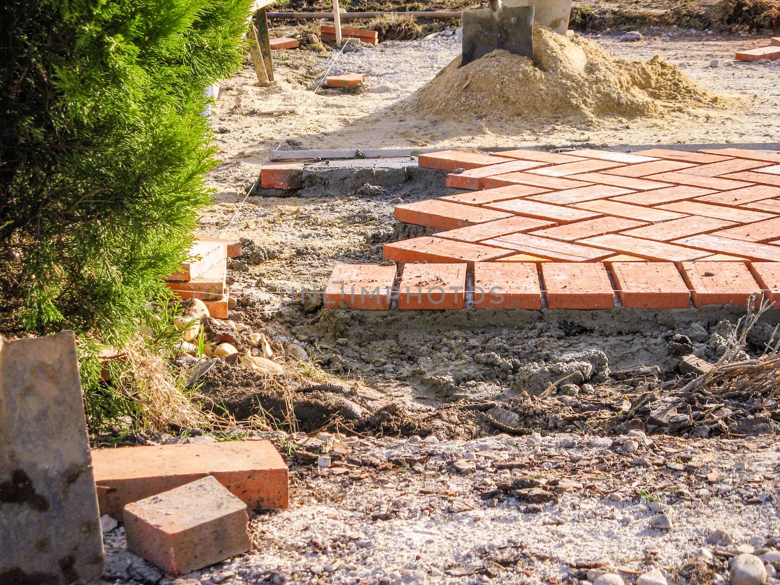 Orange brick paving stones pattern in the construction process of a courtyard