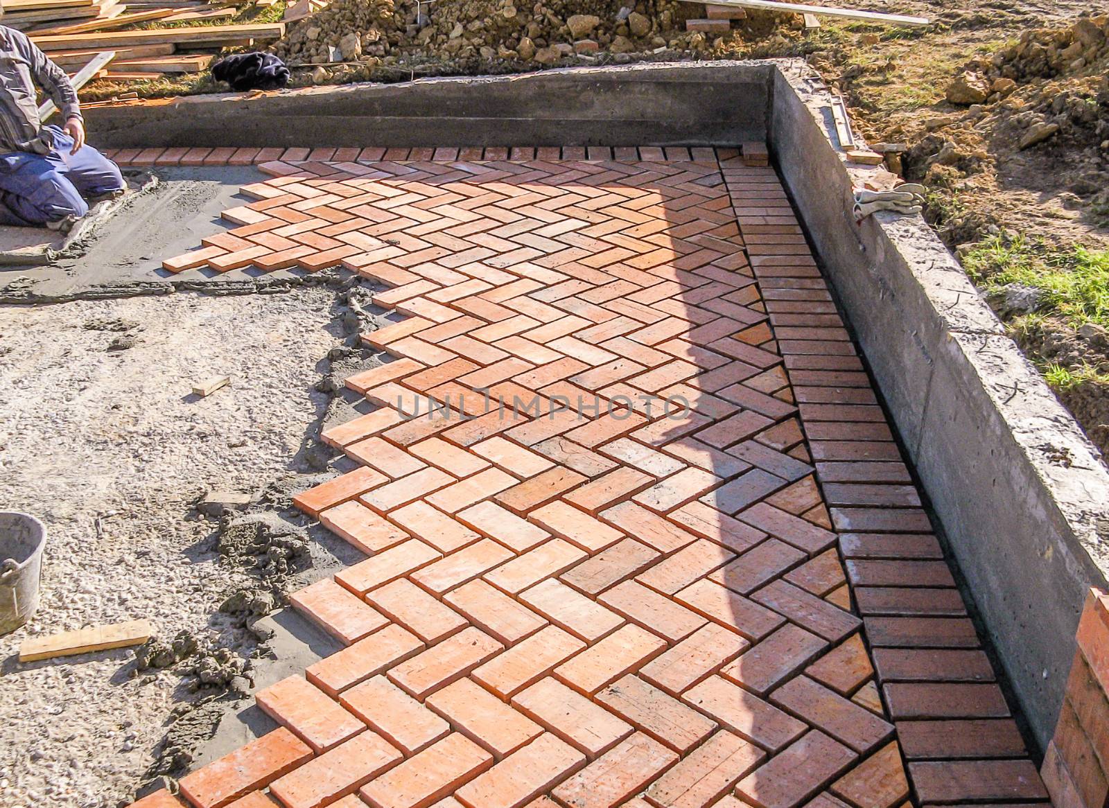 Orange brick paving stones in construction process by doble.d
