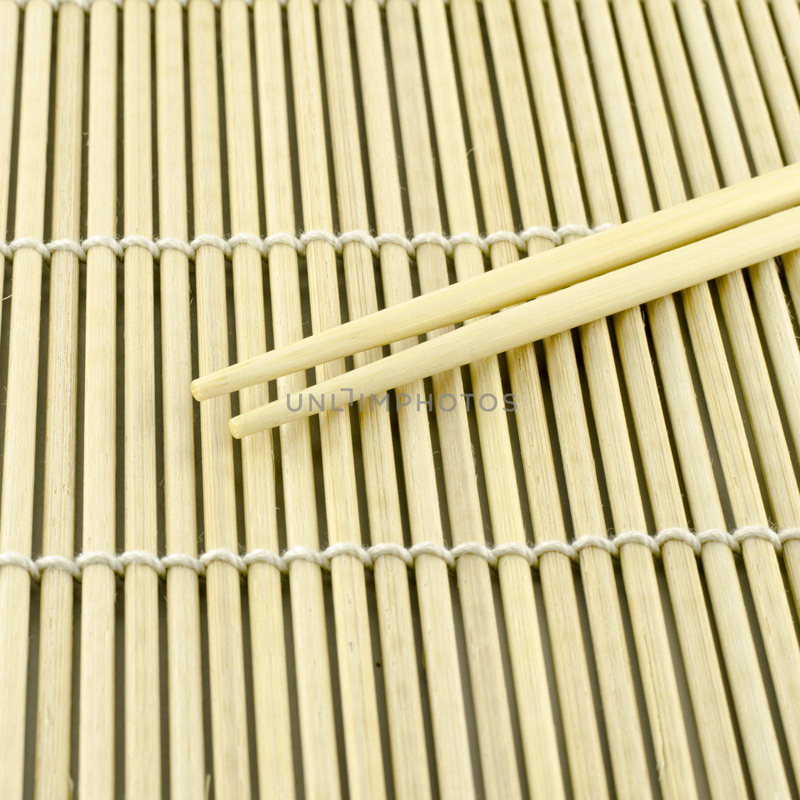 Two chopsticks on sushi mat background for menu