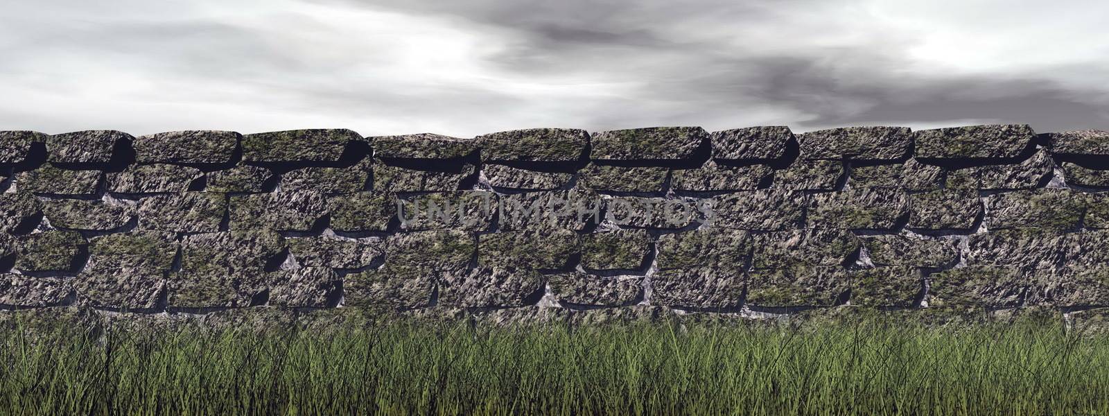 Long brick wall upon green grass in grey cloudy sky background