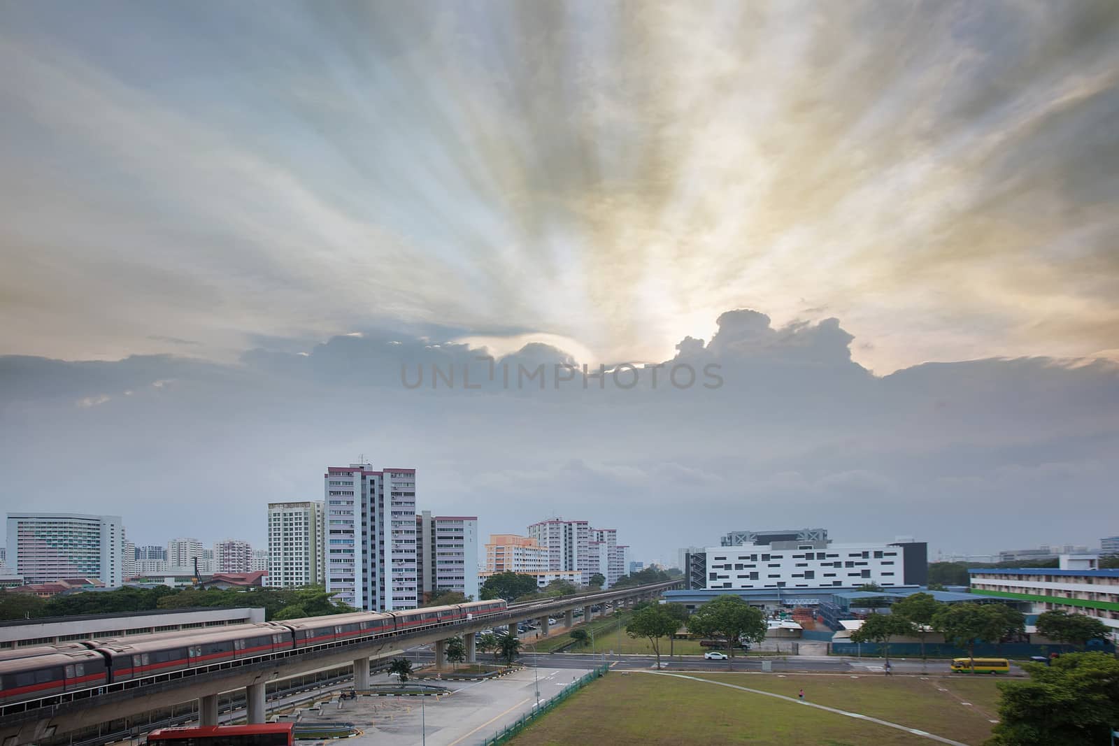 Sunset with Sun Rays Over Singapore Housing Estate by the MRT Train Track