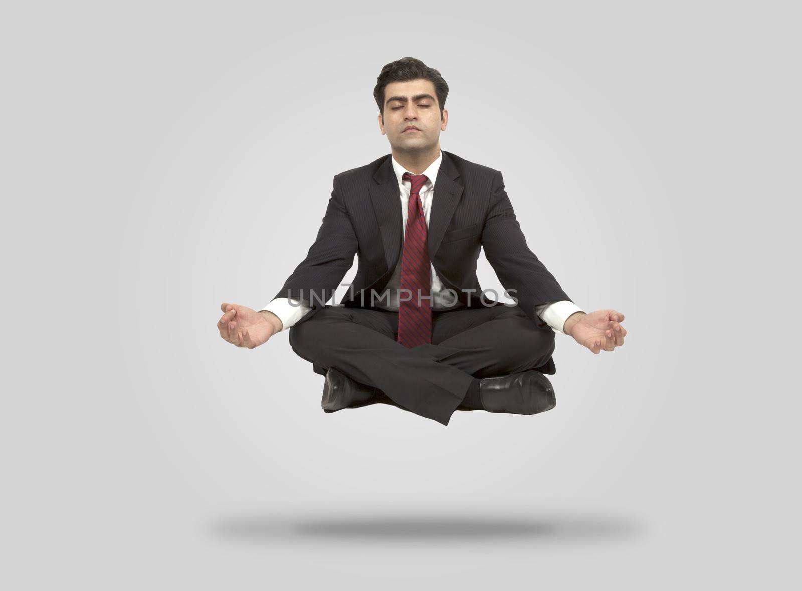 Business man meditates in mid air by haiderazim