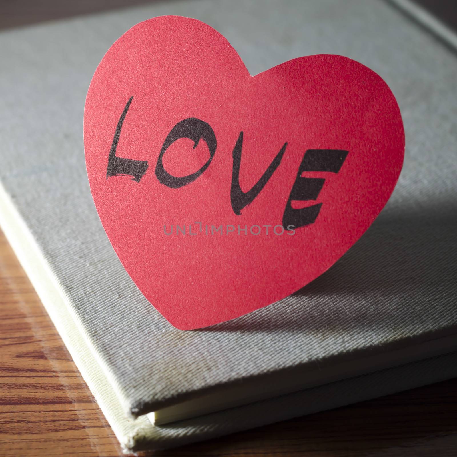 diary of love with notebook and heart on wood background