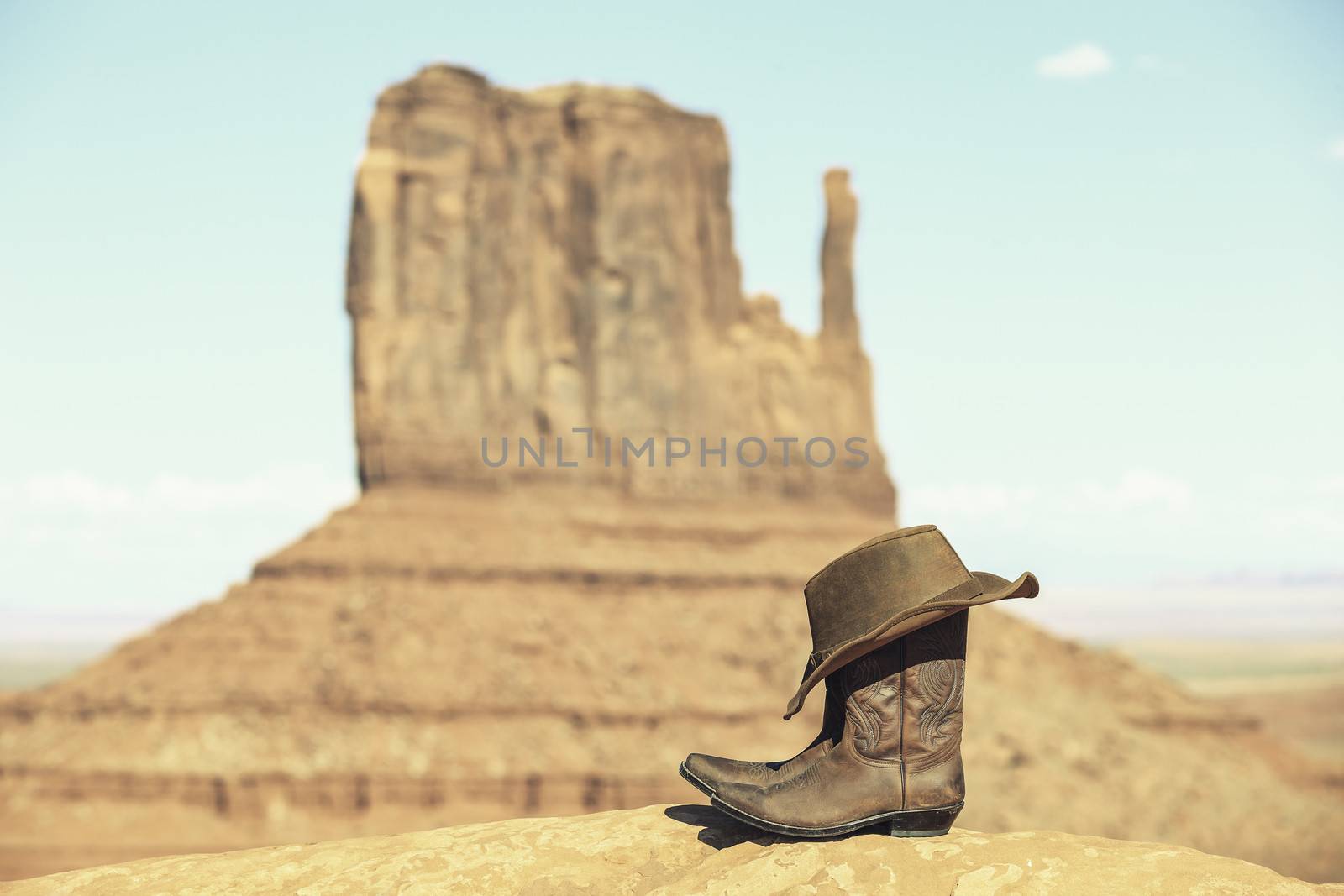 Boots and hat in front of Monument Valley with special photographic processing 