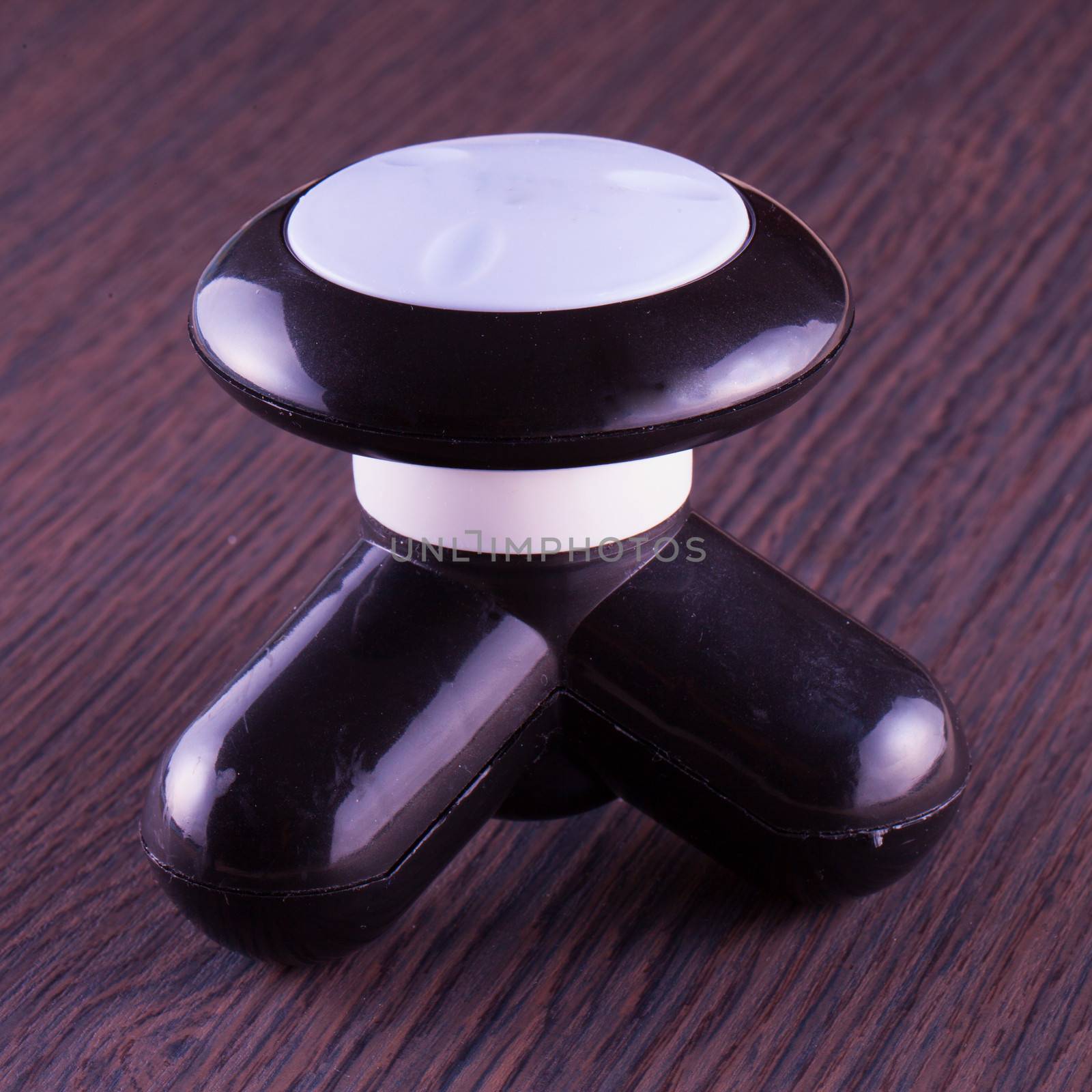 Small electric massager over wooden background, close up