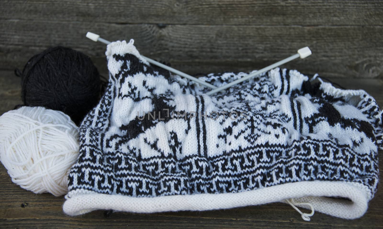 Knitting a traditional sweater with reindeer and snowflakes