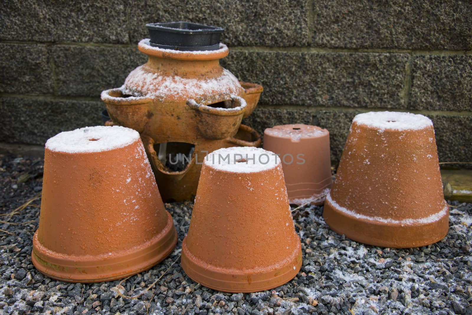 Garden terracotta pots covered in ice and snow