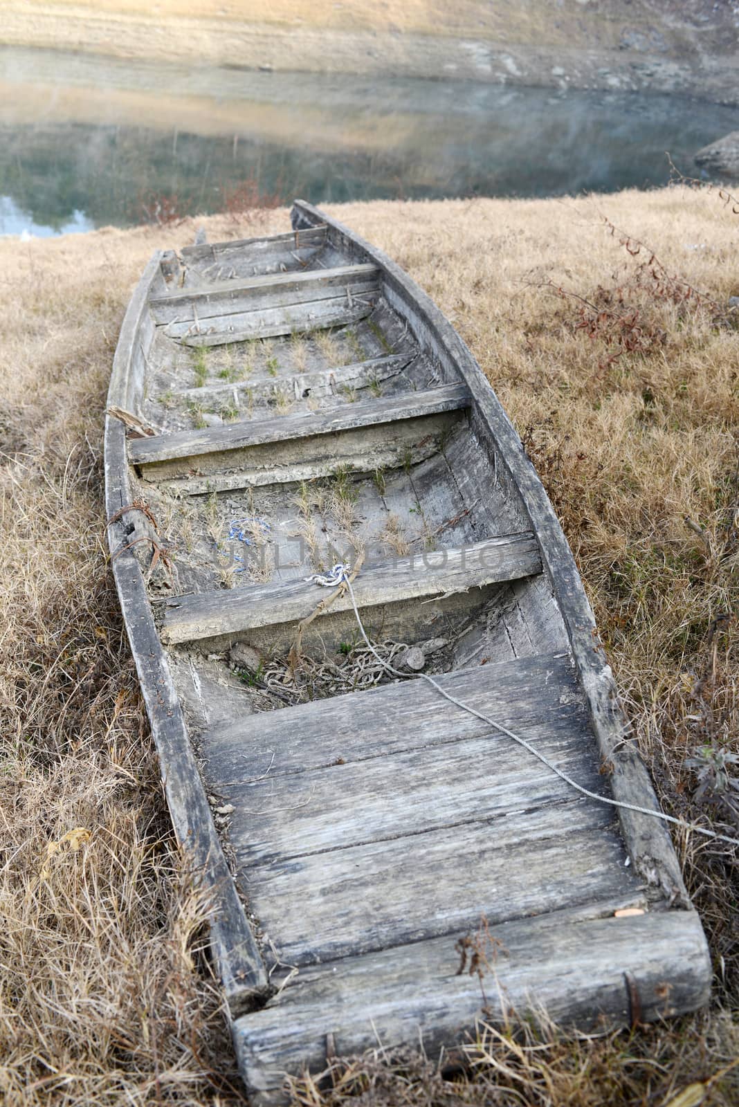 Old broken wooden boat on the lakeside