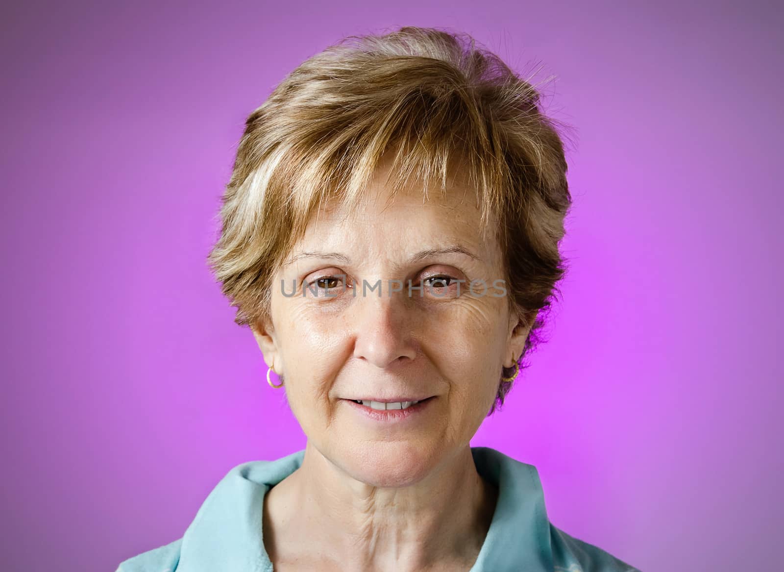 Portrait of a real happy middle aged woman over purple background