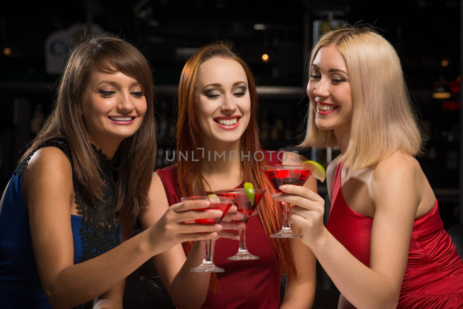 three girls raised their glasses in a nightclub, have fun with friends