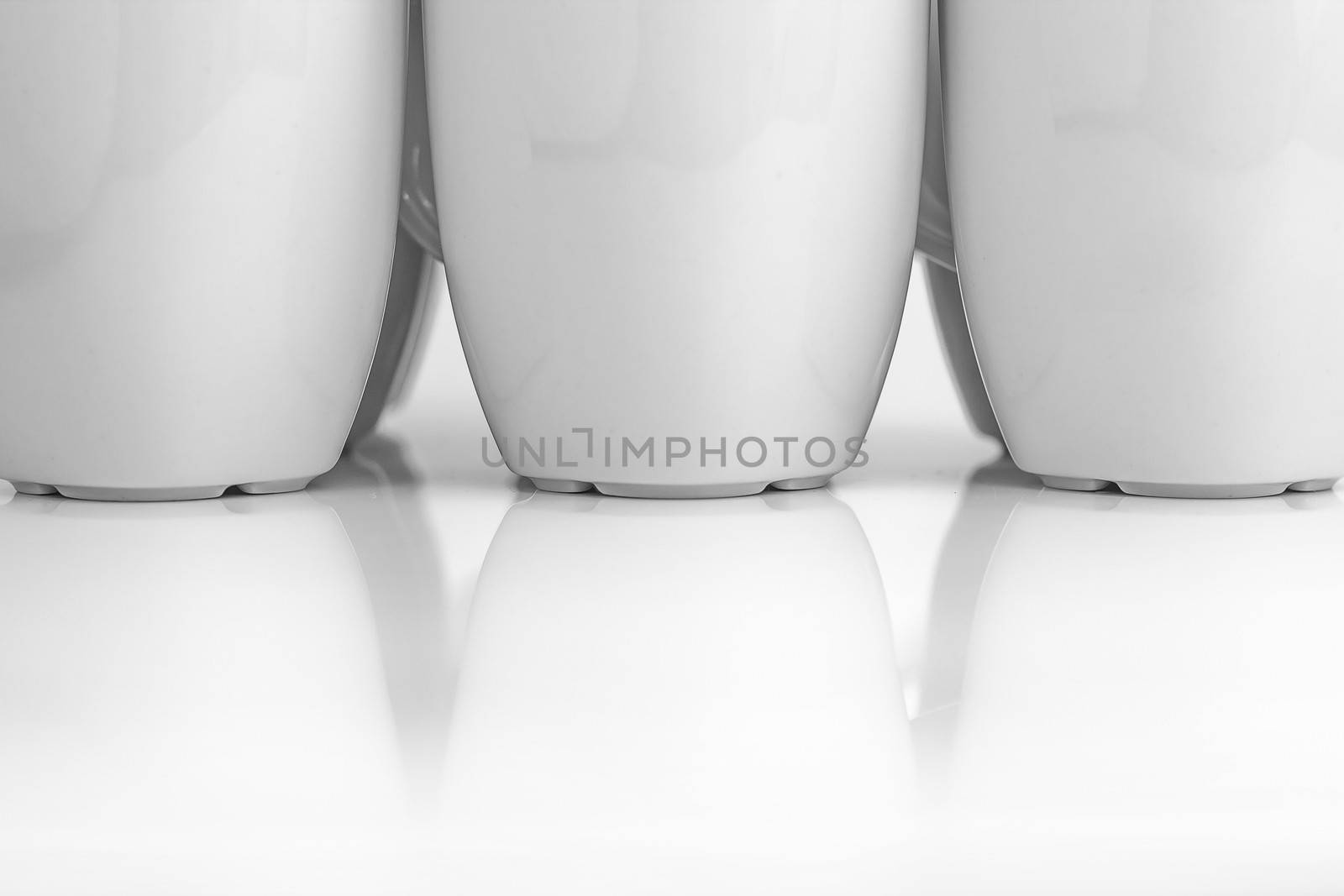 Beautiful group of white mugs over white glossy surface