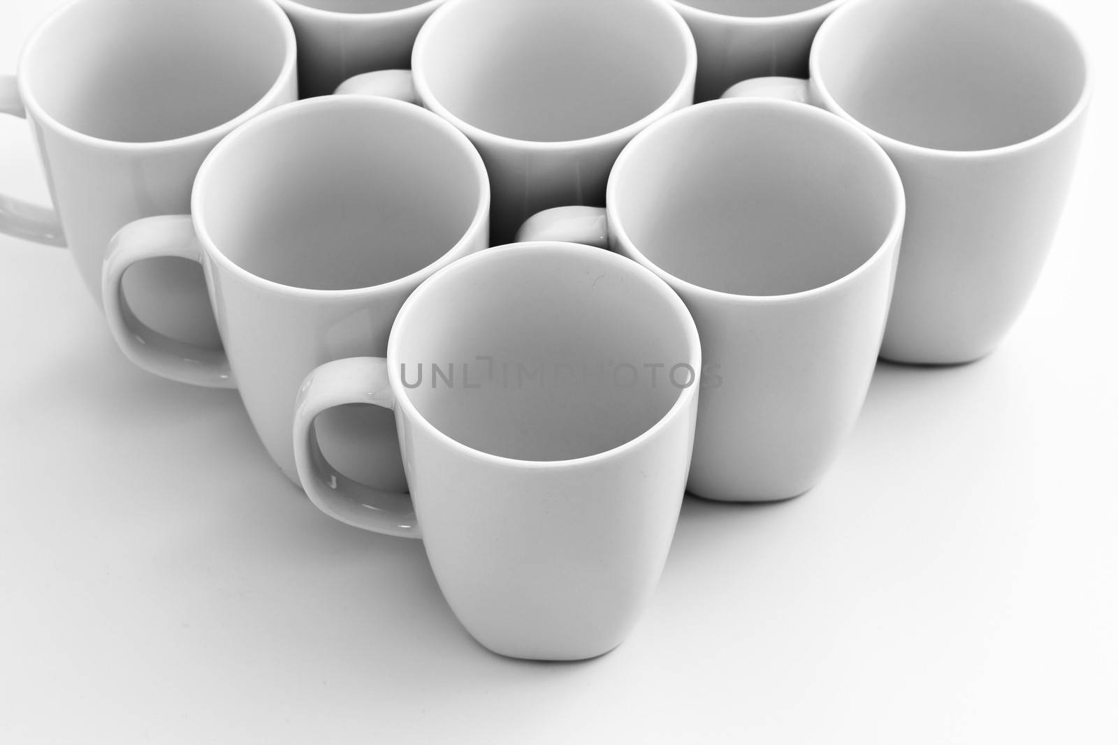 Beautiful group of white mugs over white glossy surface