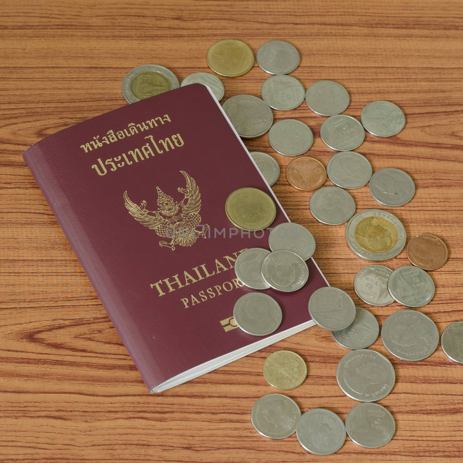 thai passport with coin on wood table background