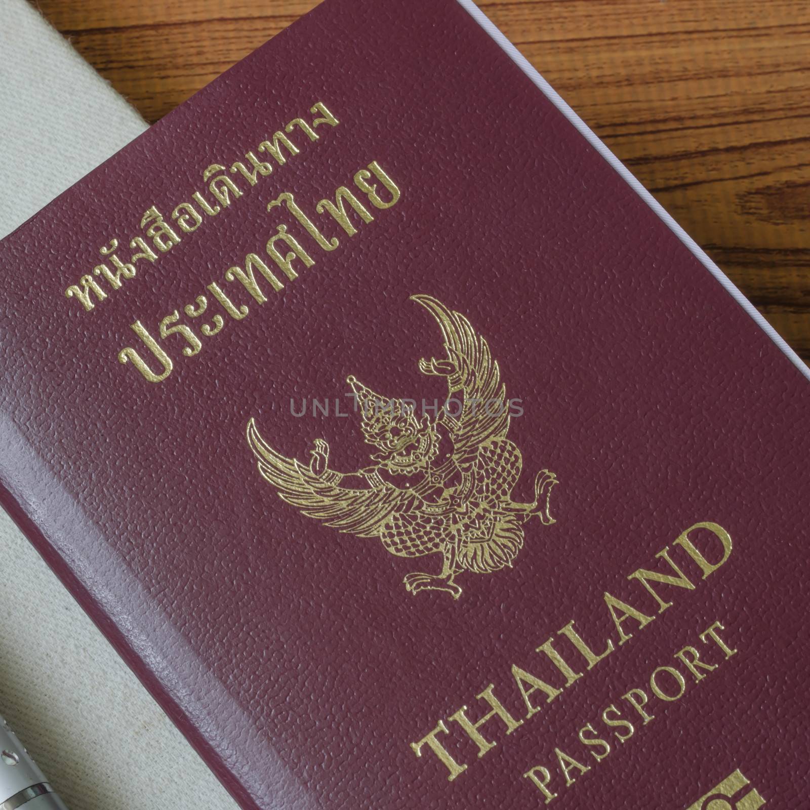 thai passport with notebook on wood table background