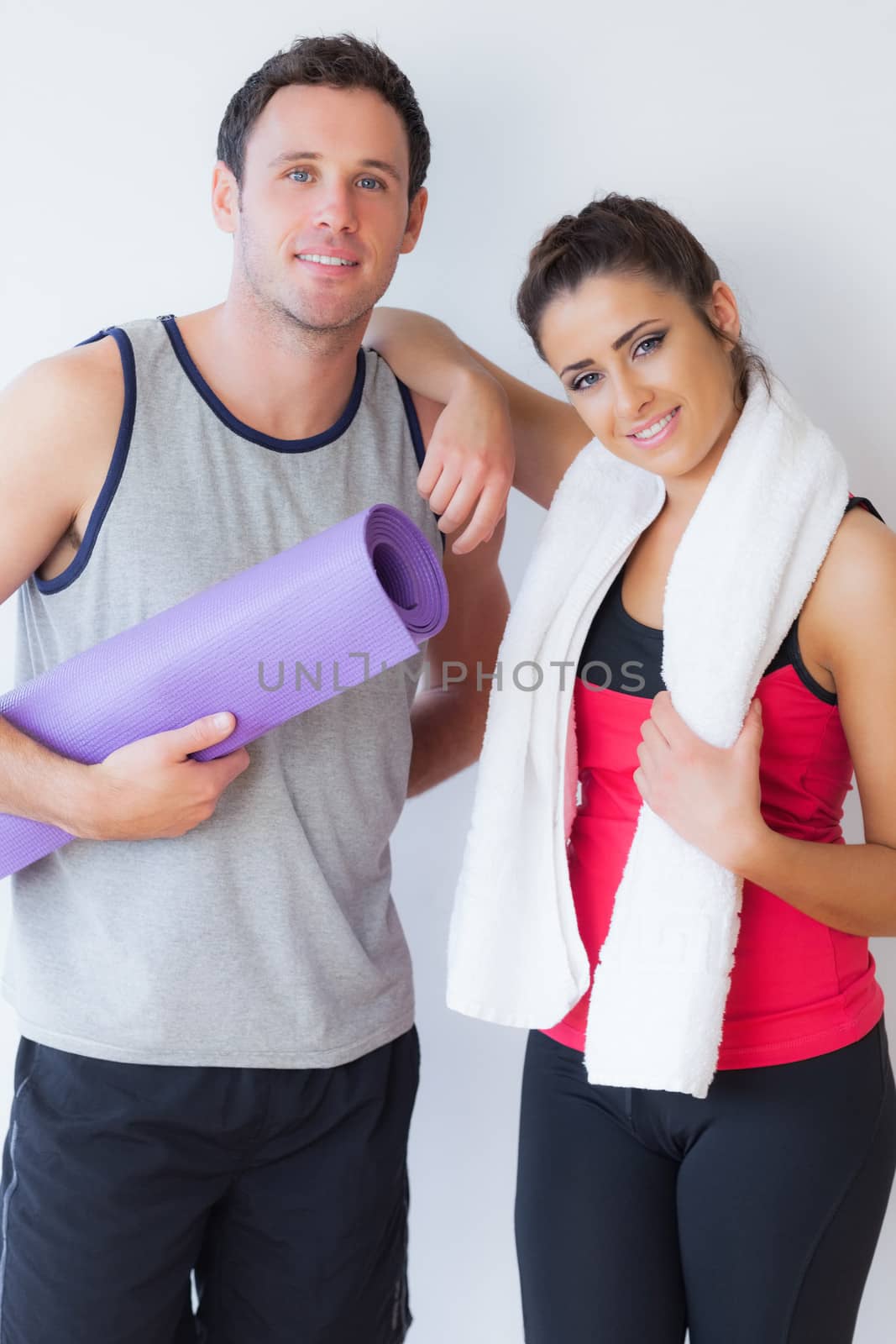 Portrait of a fit young couple with towel and exercise mat by Wavebreakmedia