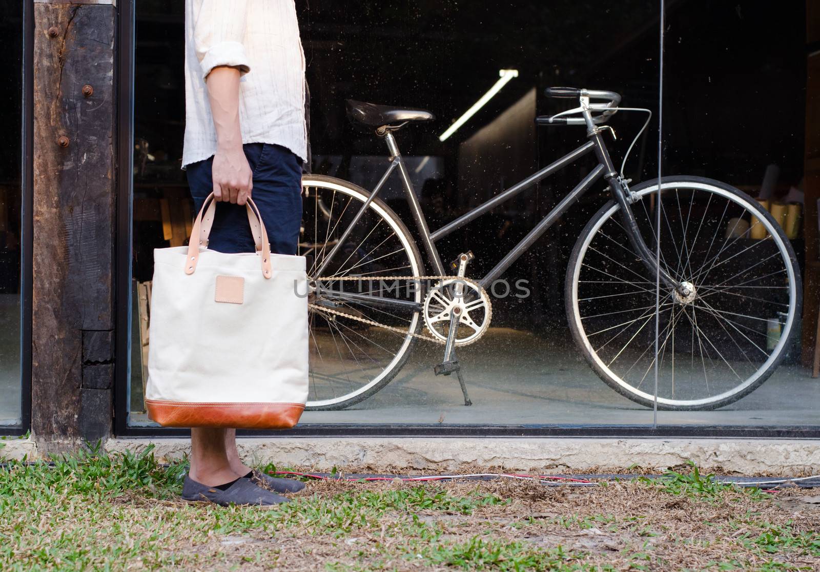 Man with canvas bag and vintage bicycle by siraanamwong