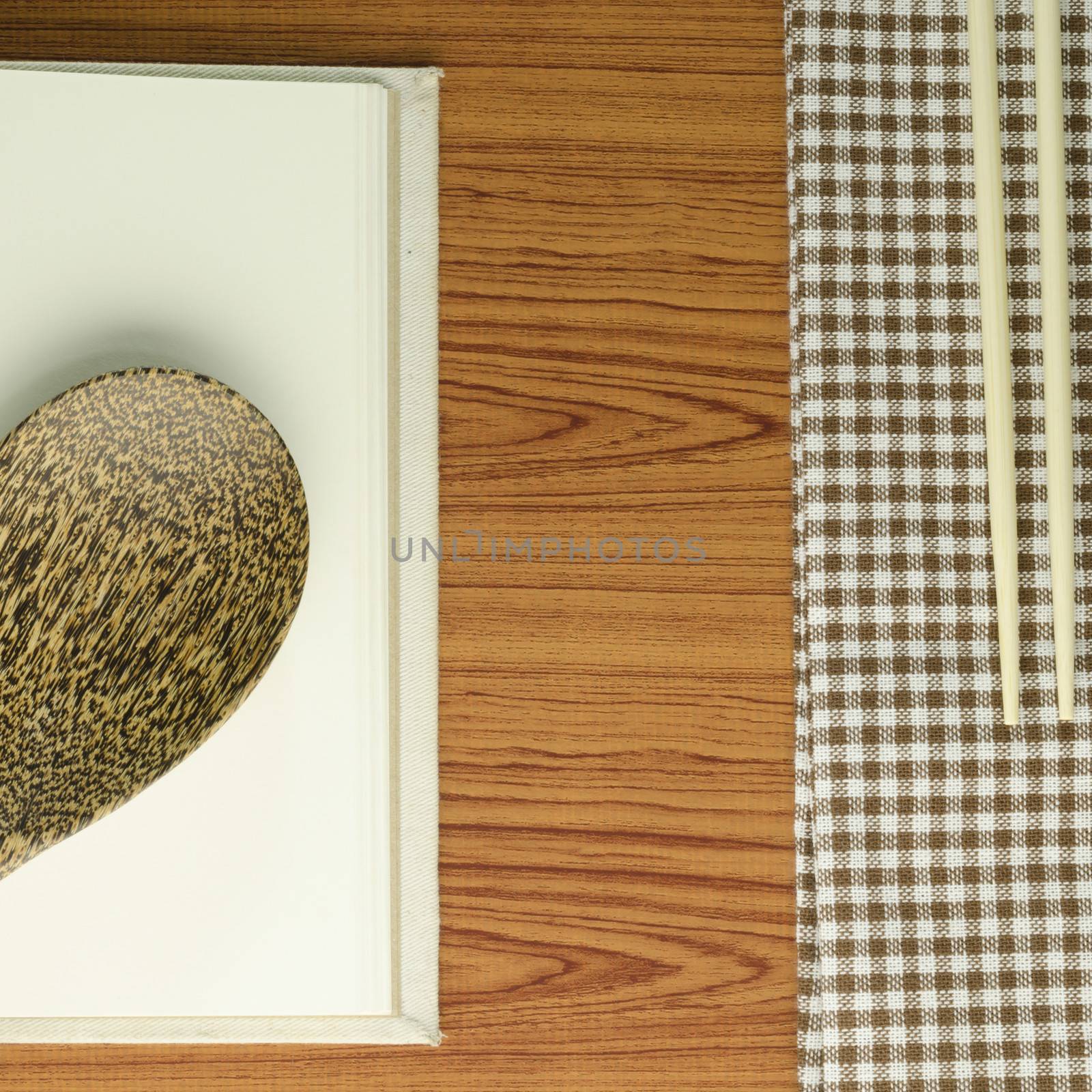 brown kitchen towel with spoon on wood background