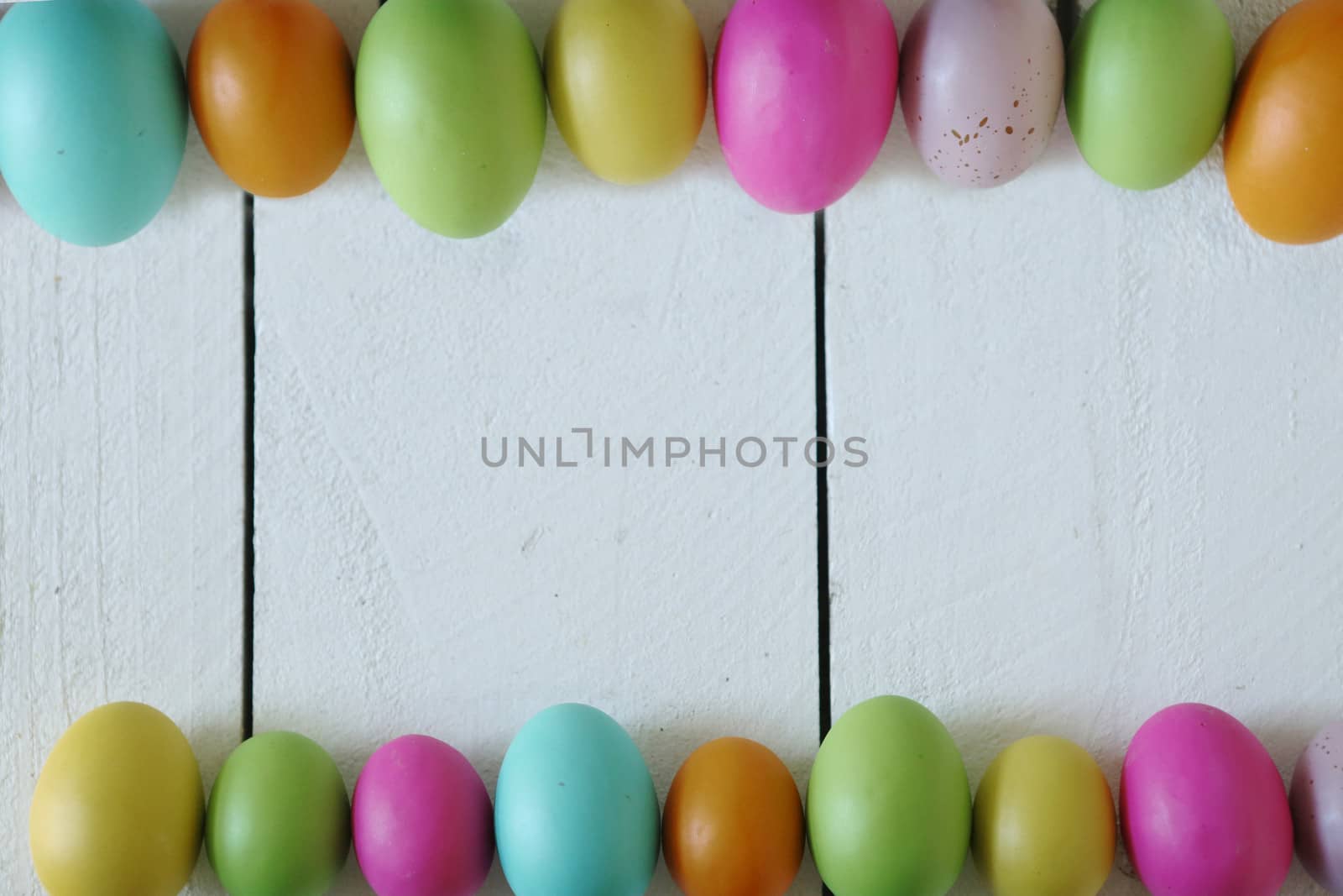 Spring or Easter Themed Background of Old Wood and Colored Eggs Lined Up