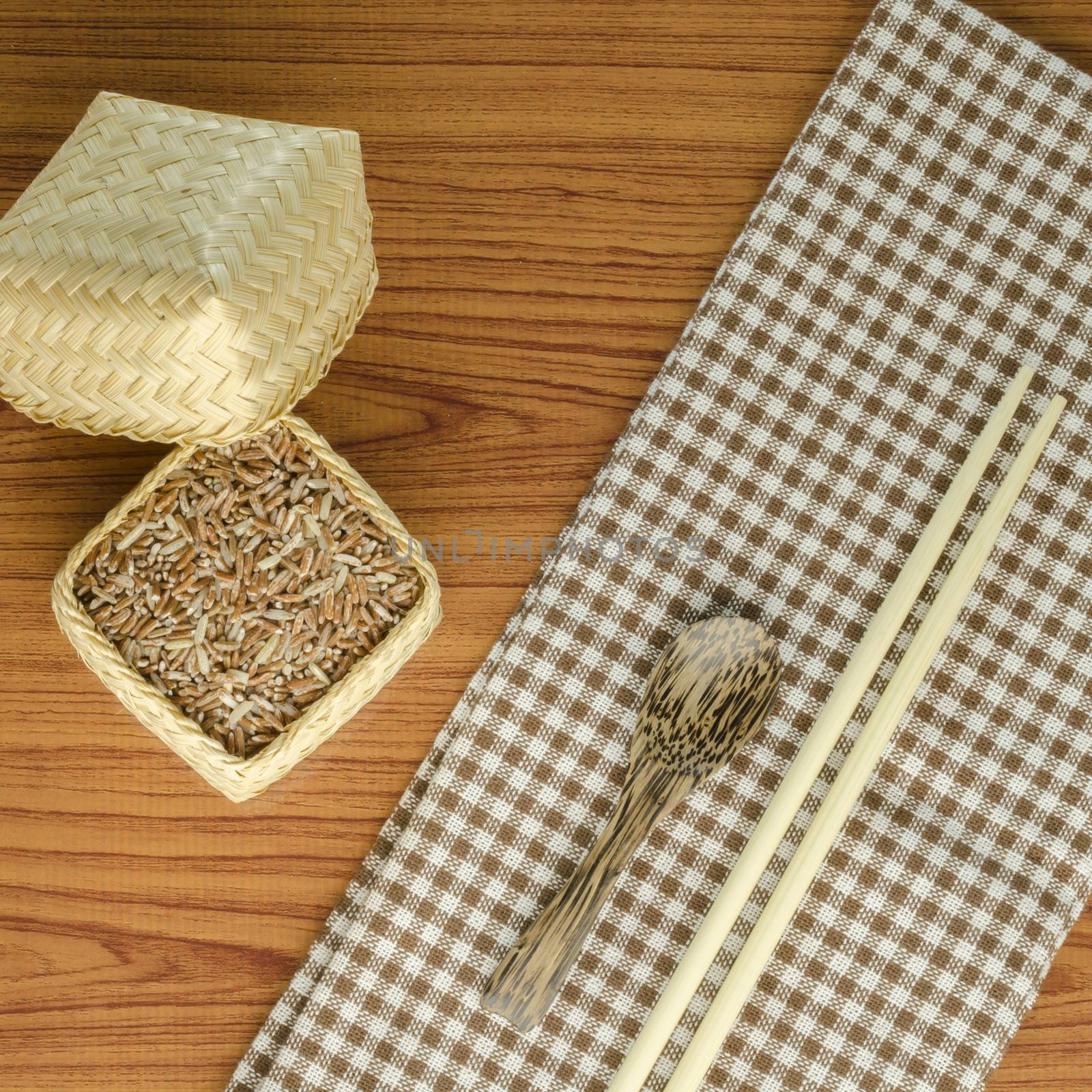 brown kitchen towel with spoon on wood background