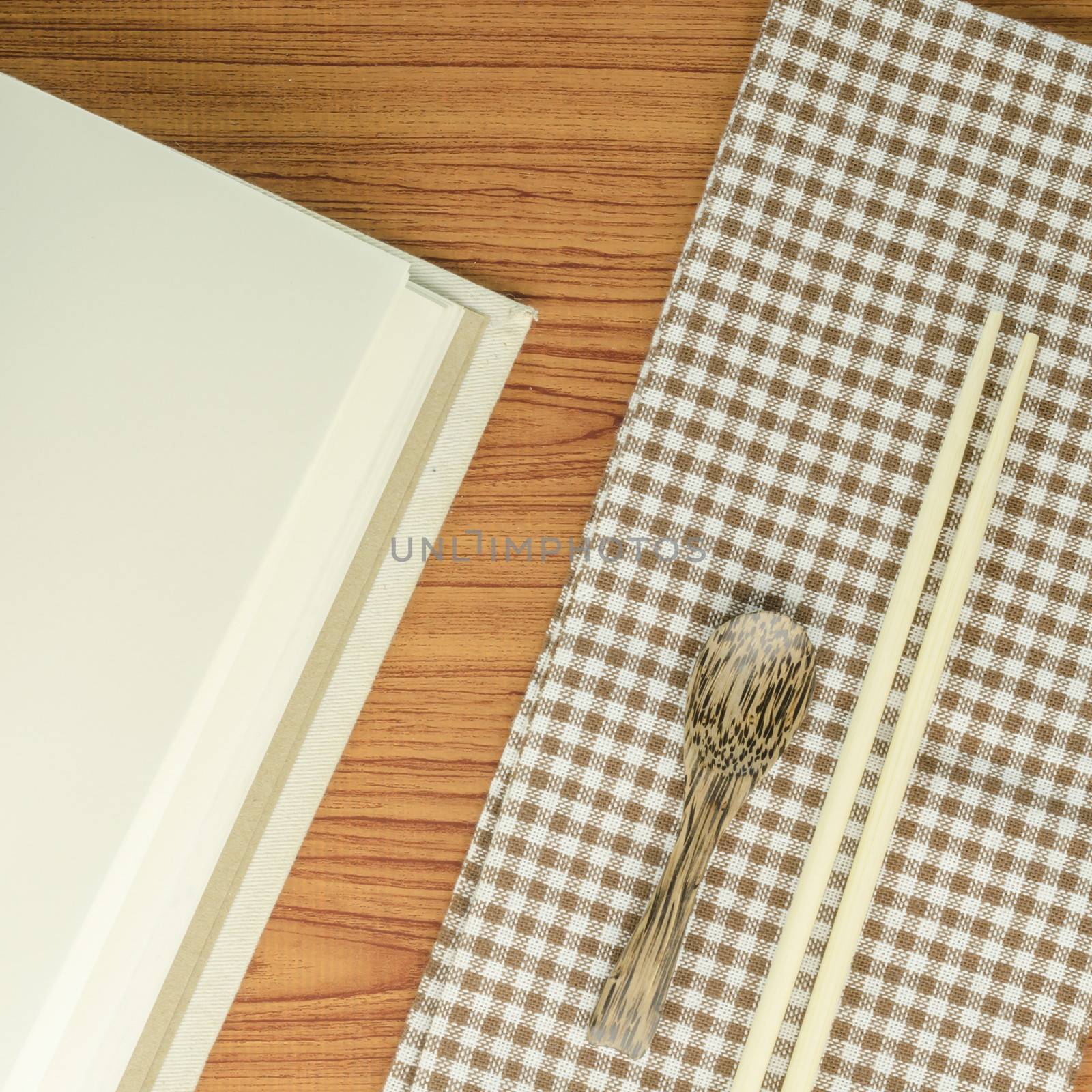 brown kitchen towel with spoon on wood background