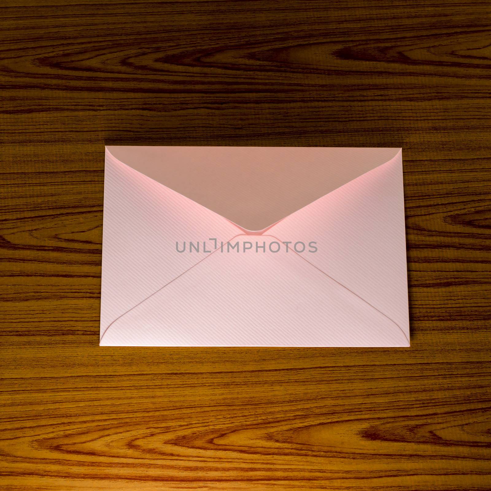 soft pink envelope on wooden background