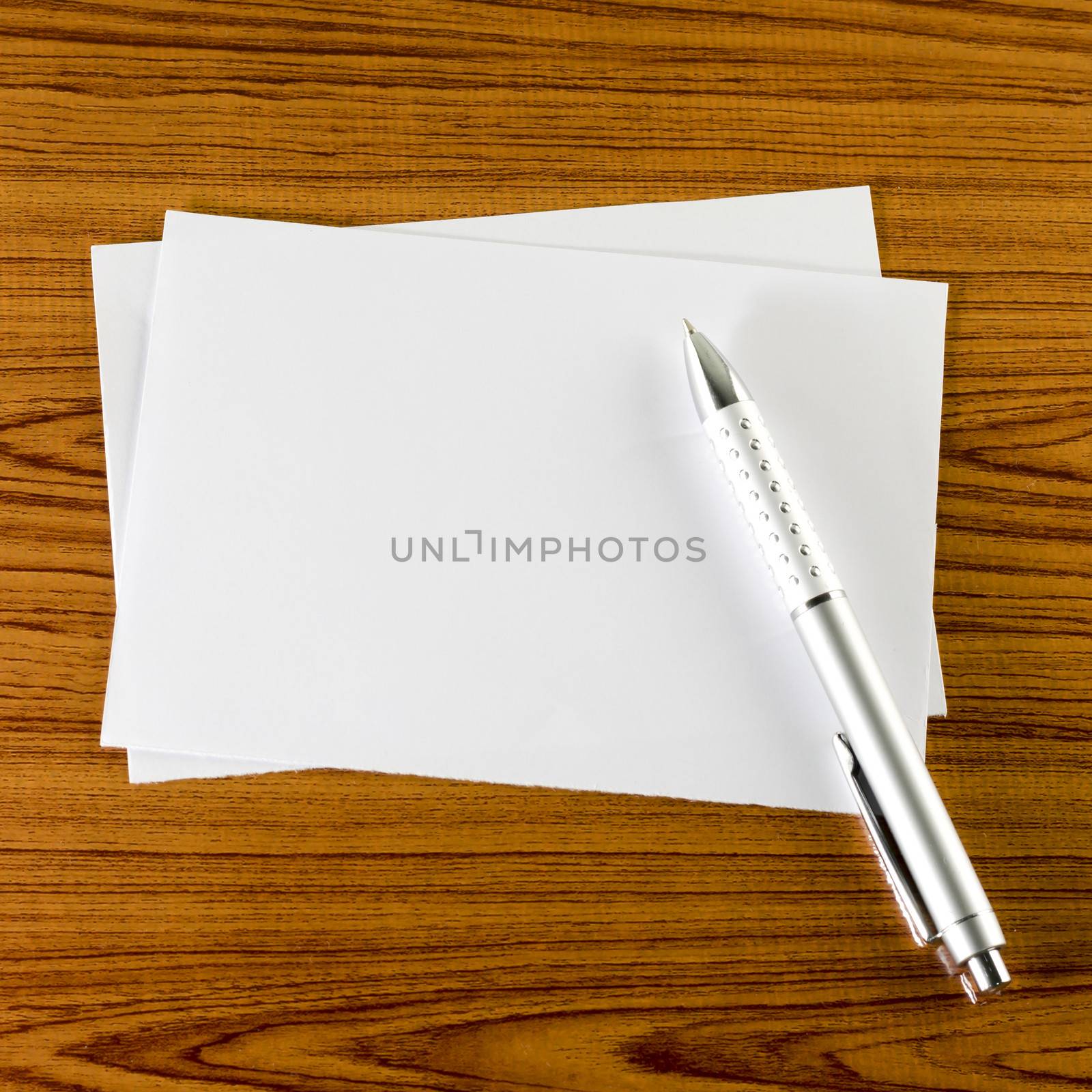 pen with white paper on wooden background