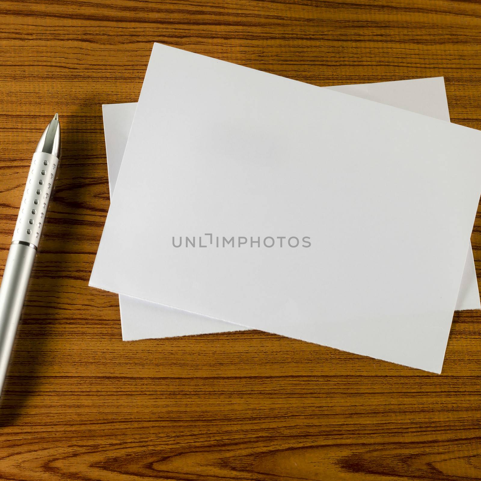 pen with white paper on wooden background