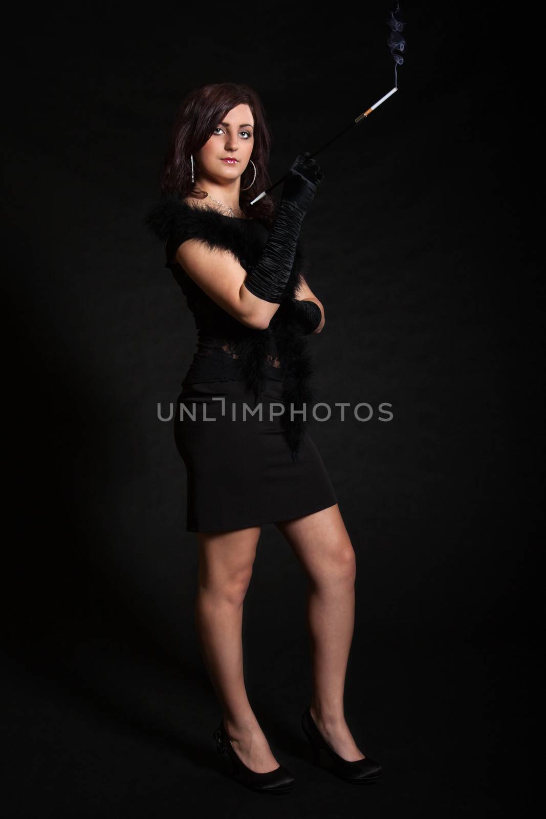 Young woman in retro clothing posing with cigarette holder