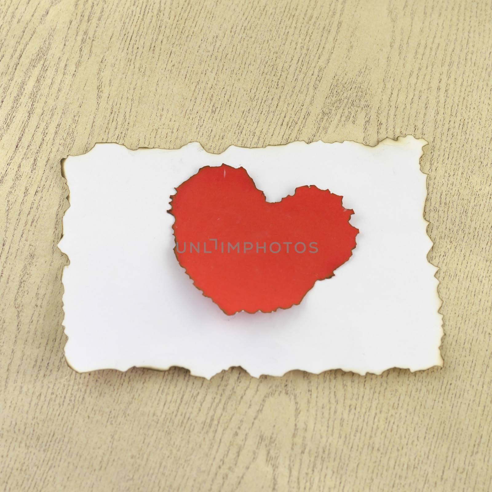 heart and white paper on wood background