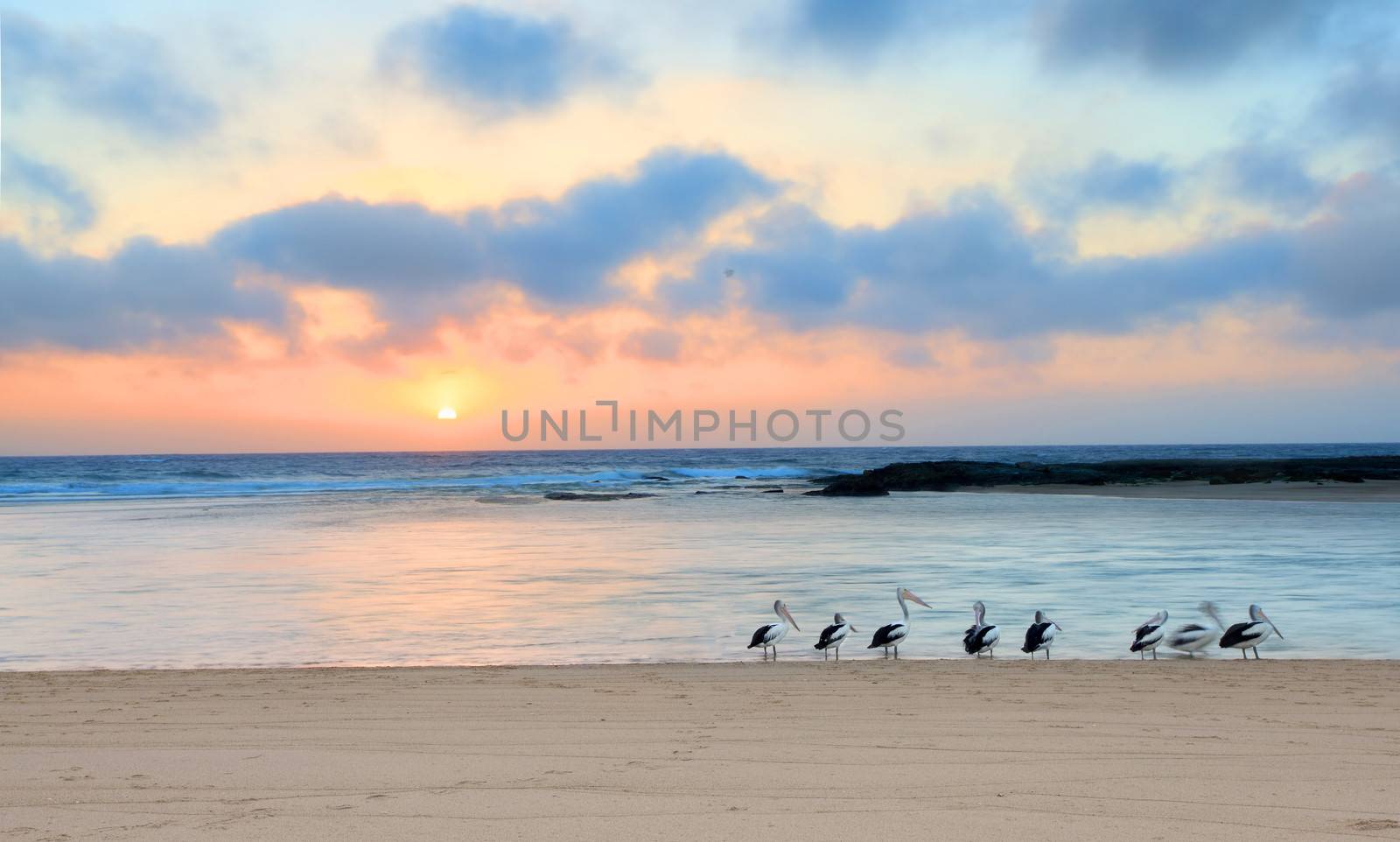 The sun rises up at the horizon at The Entrance North, on a beautiful summer day in Australia