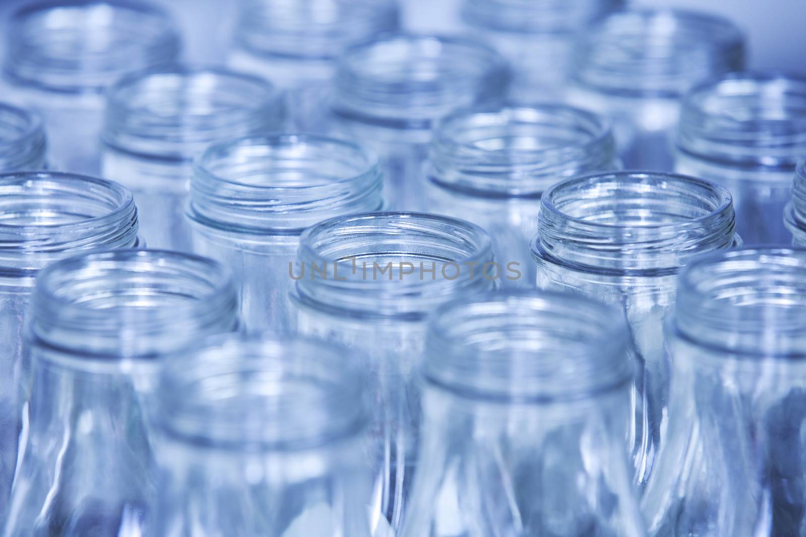 Rows of glass bottles ready for recycling, shallow depth of field