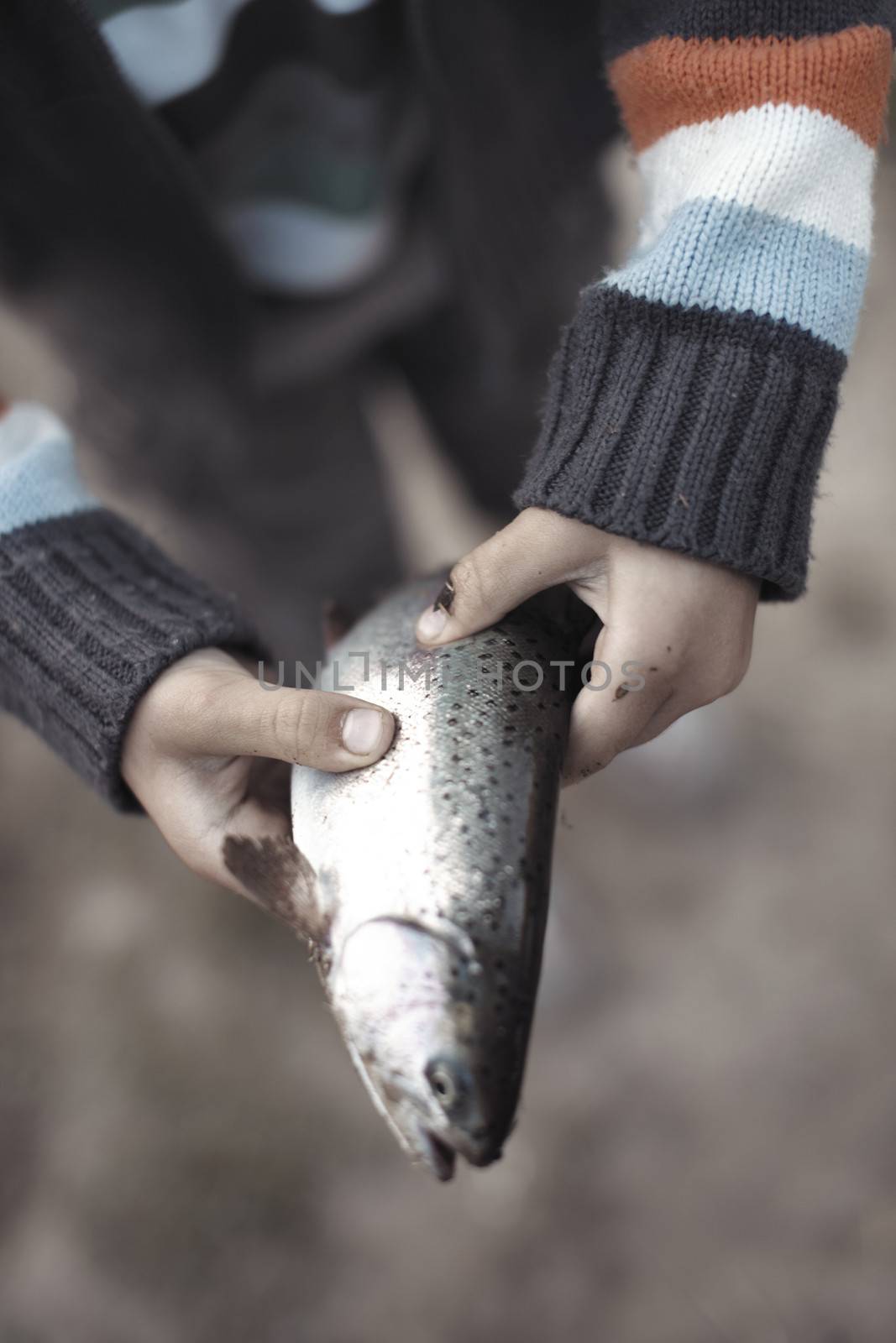Teenager holding fresh trapped fish. Vertical photo